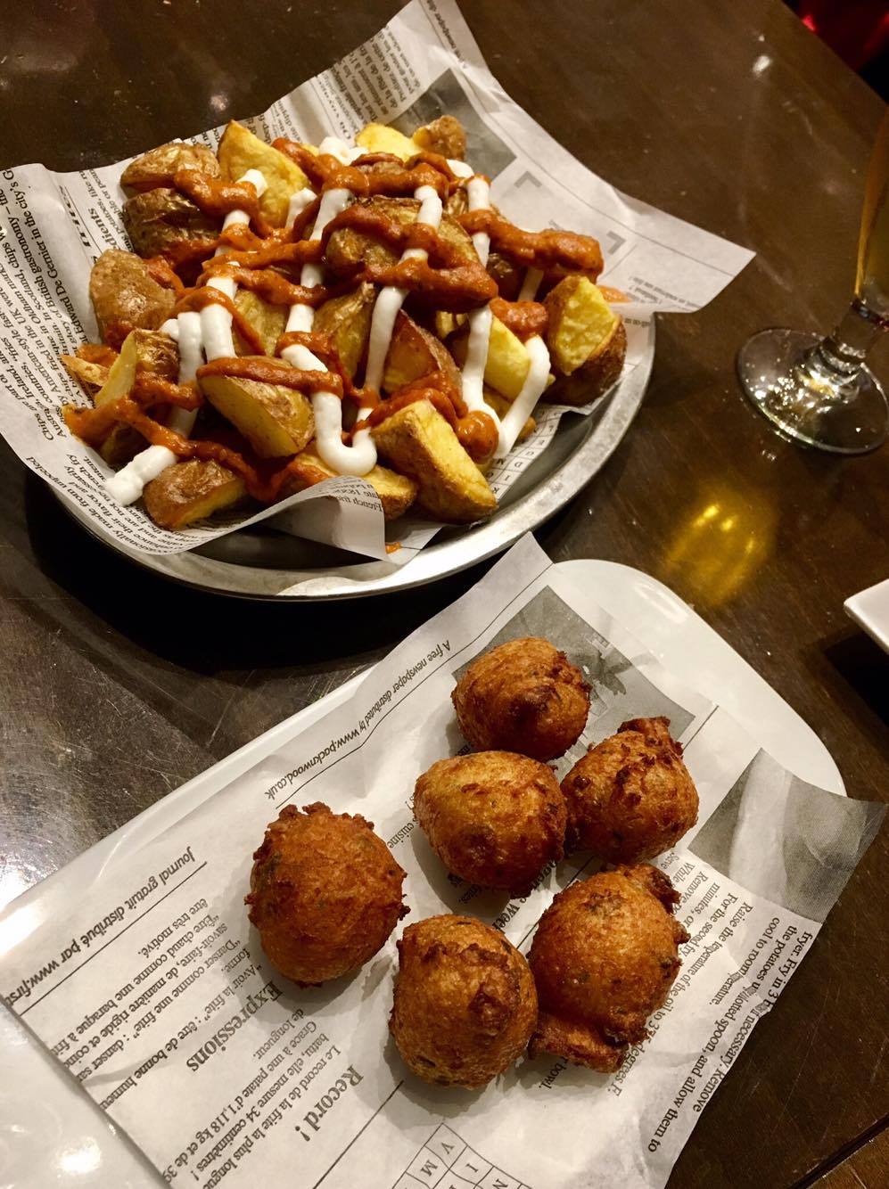  Top left: Patatas bravas, a staple tapas served across Spain. Fried potato wedges with aioli and spicy tomato sauce. Bottom right: another dish of fried croquetas, with a different filling. 