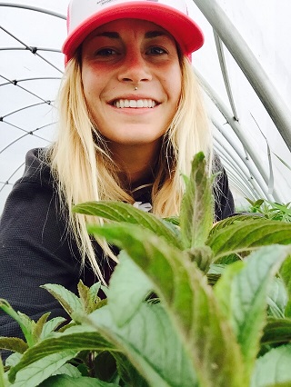 The author, Eliza Demarest, as a volunteer at Sustainable Settings , with her nose in some freshly grown mint. 