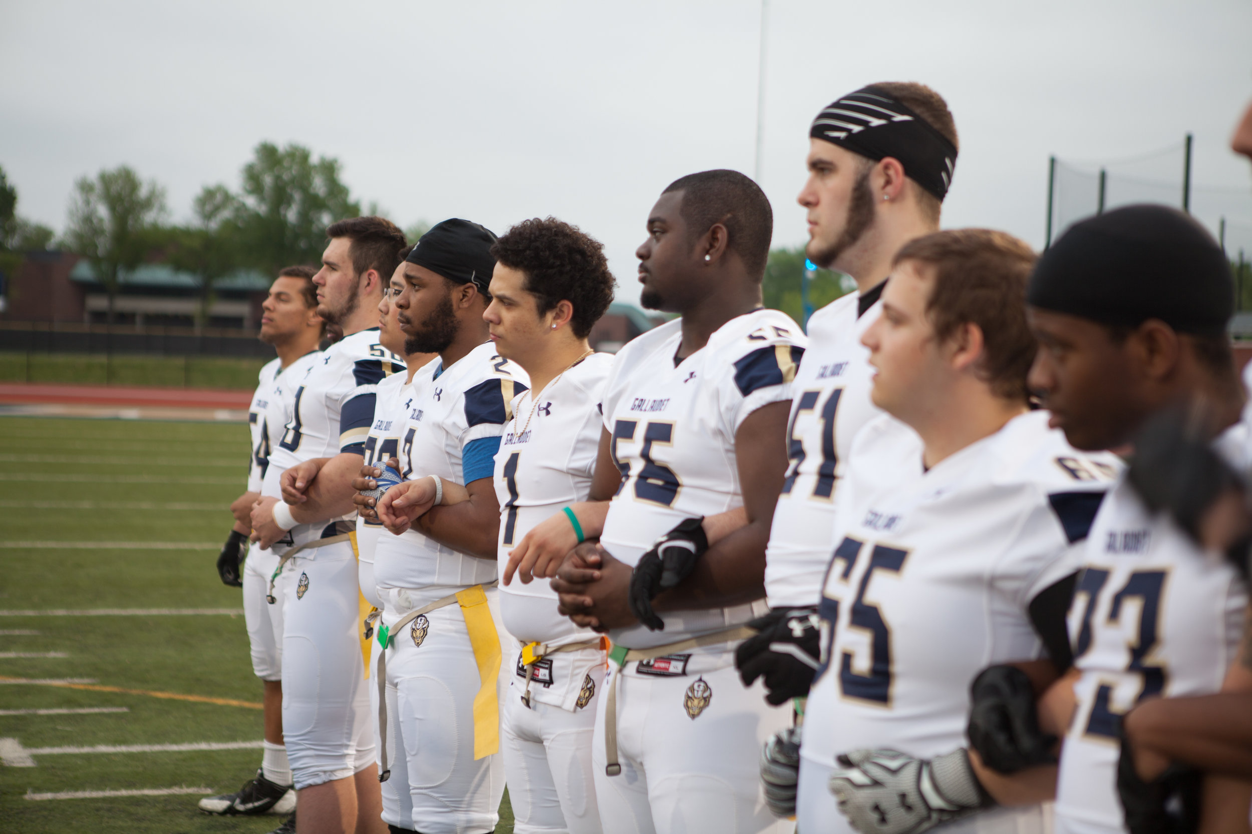 Players link arms before their annual spring scrimmage on April 27, 2016 at Gallaudet University.