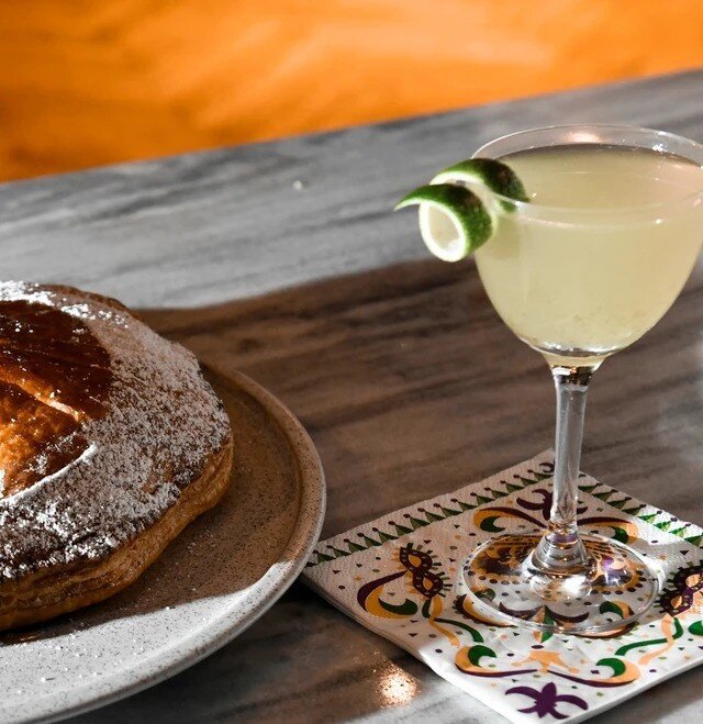 Celebrating Mardi Gras with a slice of King Cake in one hand and a cocktail in the other, because there's no better way to imbibe in the festivities than in the heart of New Orleans. 🎷🎭️🧳