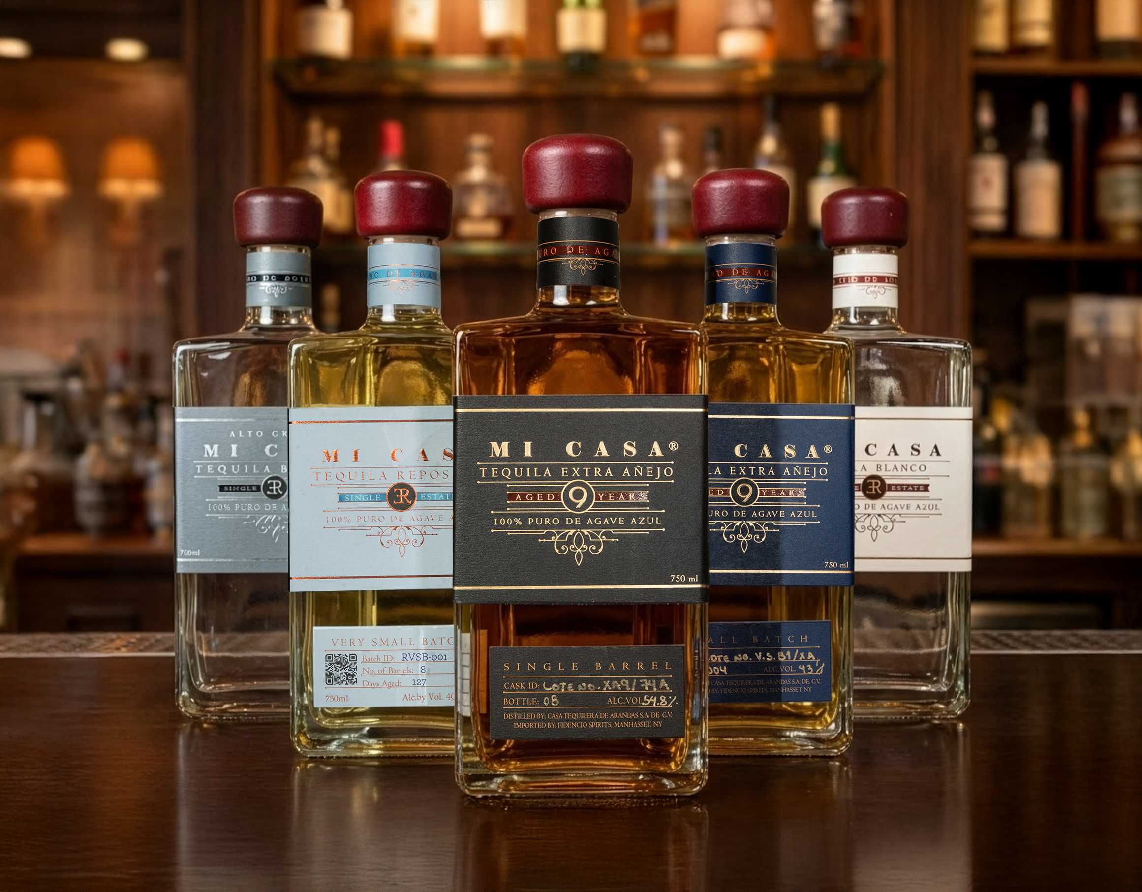 The Mi Casa Tequila portfolio — Alto Grado, Reposado VSB, Extra Añejo Single Barrel, Extra Añejo Small Batch, and Blanco — on a bar top