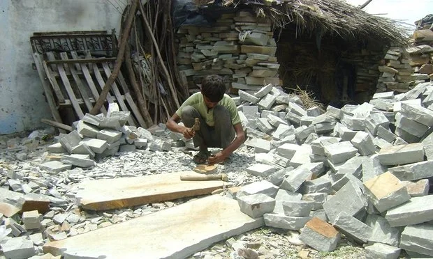 Child labourer works at sandstone in a South India quarry.