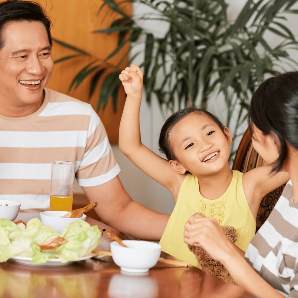 Child happy at mealtime with parents - not having a mealtime tantrum or refusing food