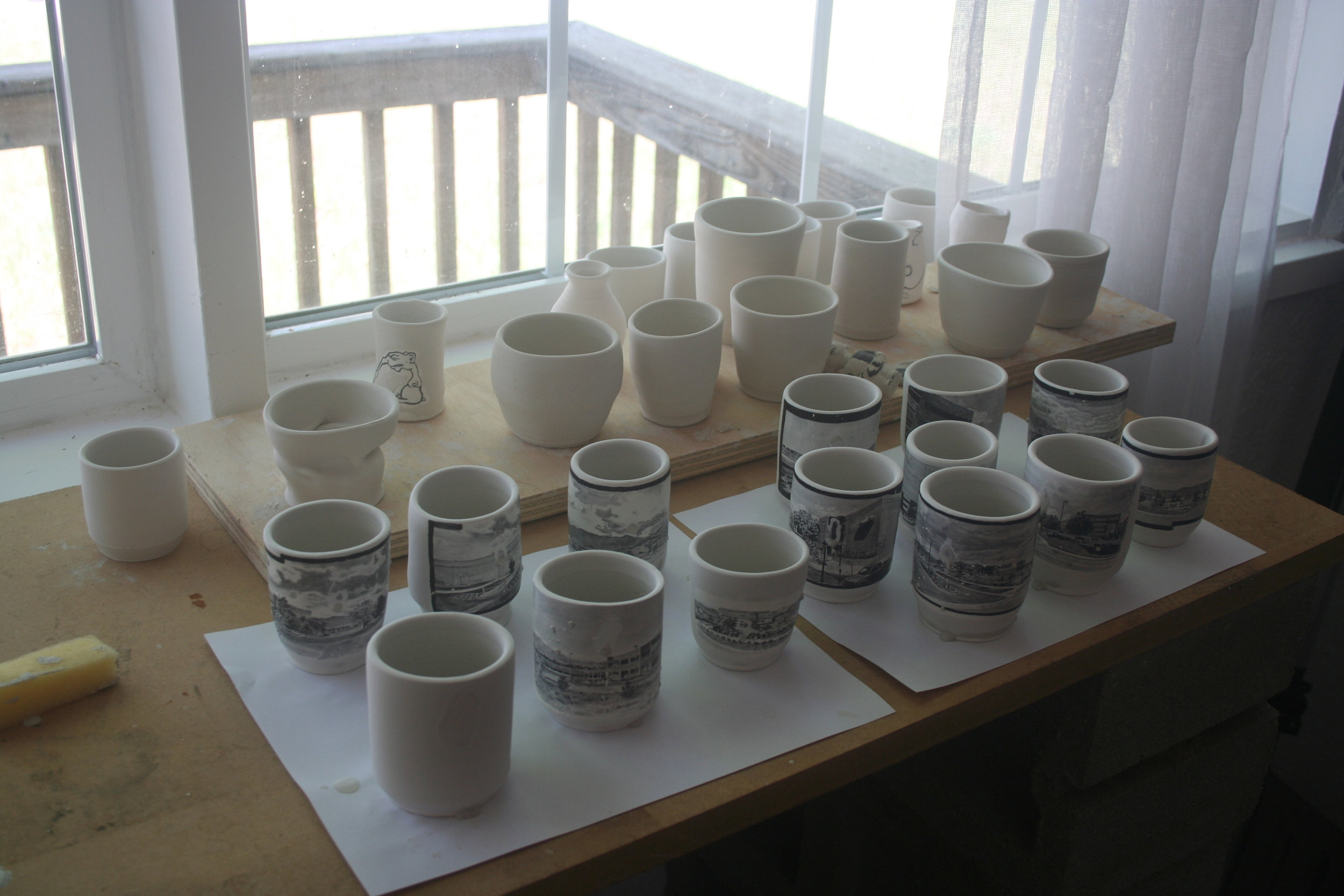 Glaze application using a wax-resist to keep the images free of glaze.