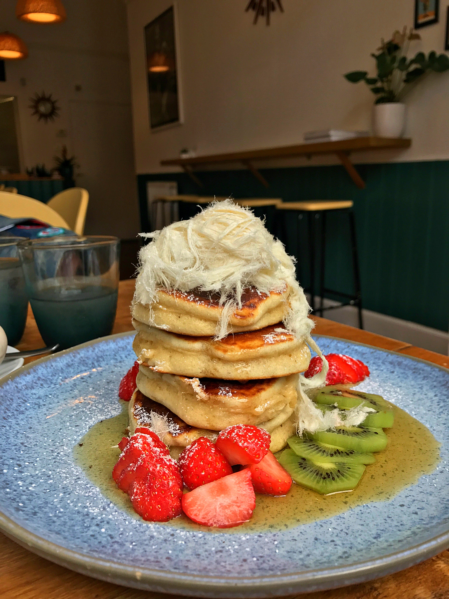 Hot cakes with strawberries, blueberries, kiwi fruit, pashmak, maple syrup