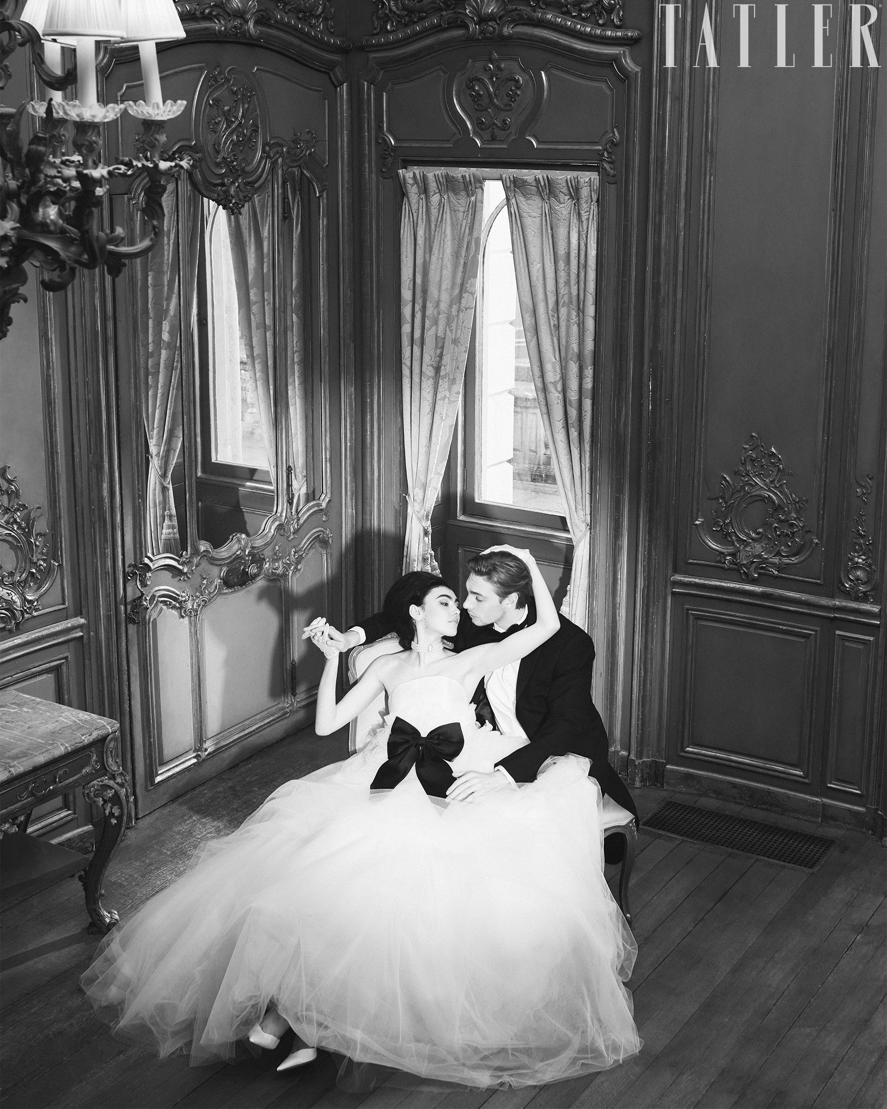 Strapless wedding gown with voluminous layered tulle skirt and contemporary bridal silhouette, with black bow in Tatler Magazine