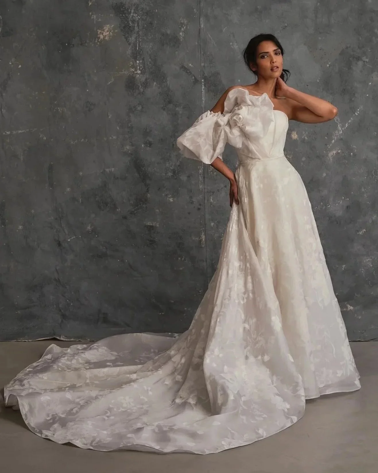 Modern bridal gown with statement floral organza sleeve, full skirt and elegant train