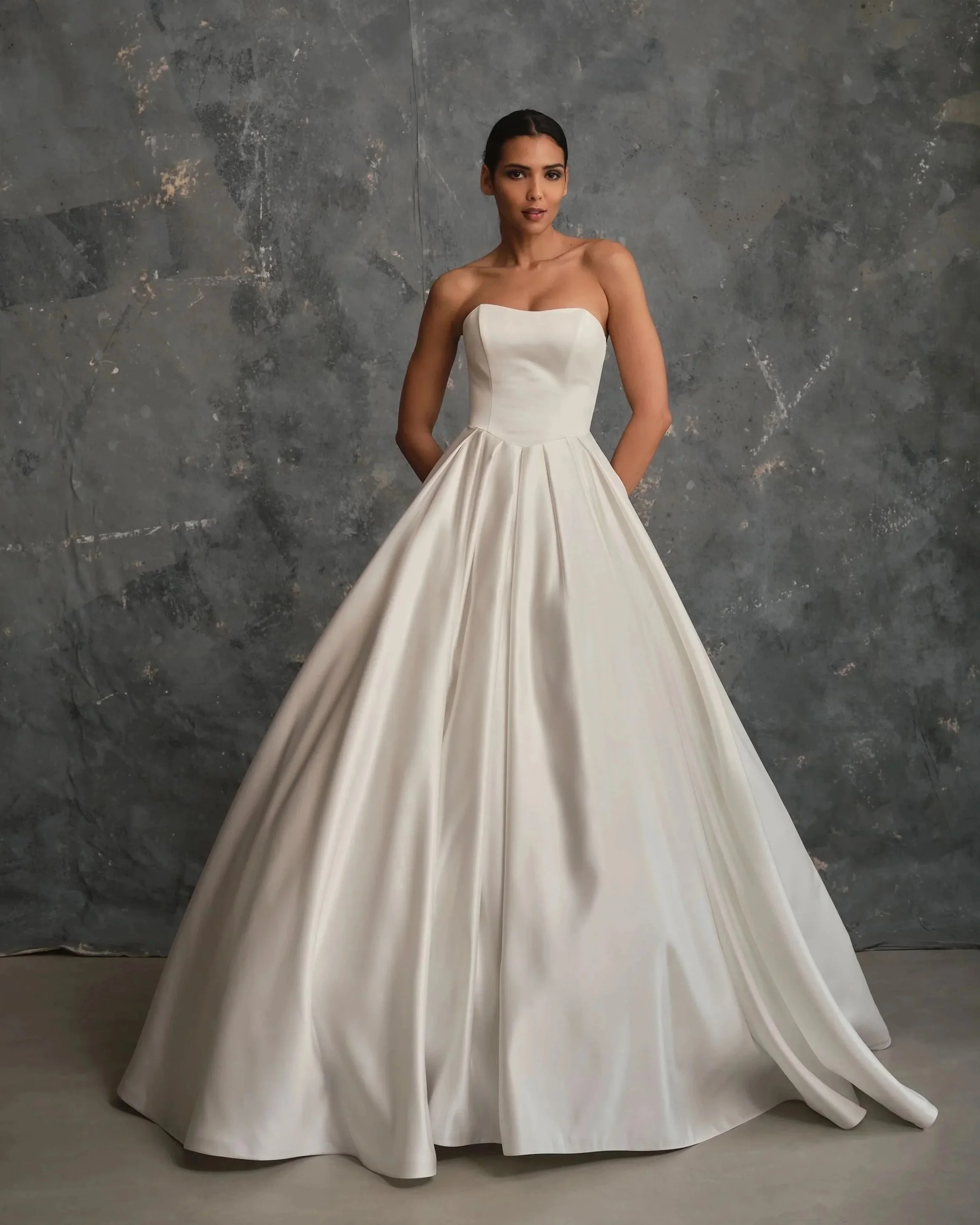 Front view of minimalist satin wedding gown with structured bodice