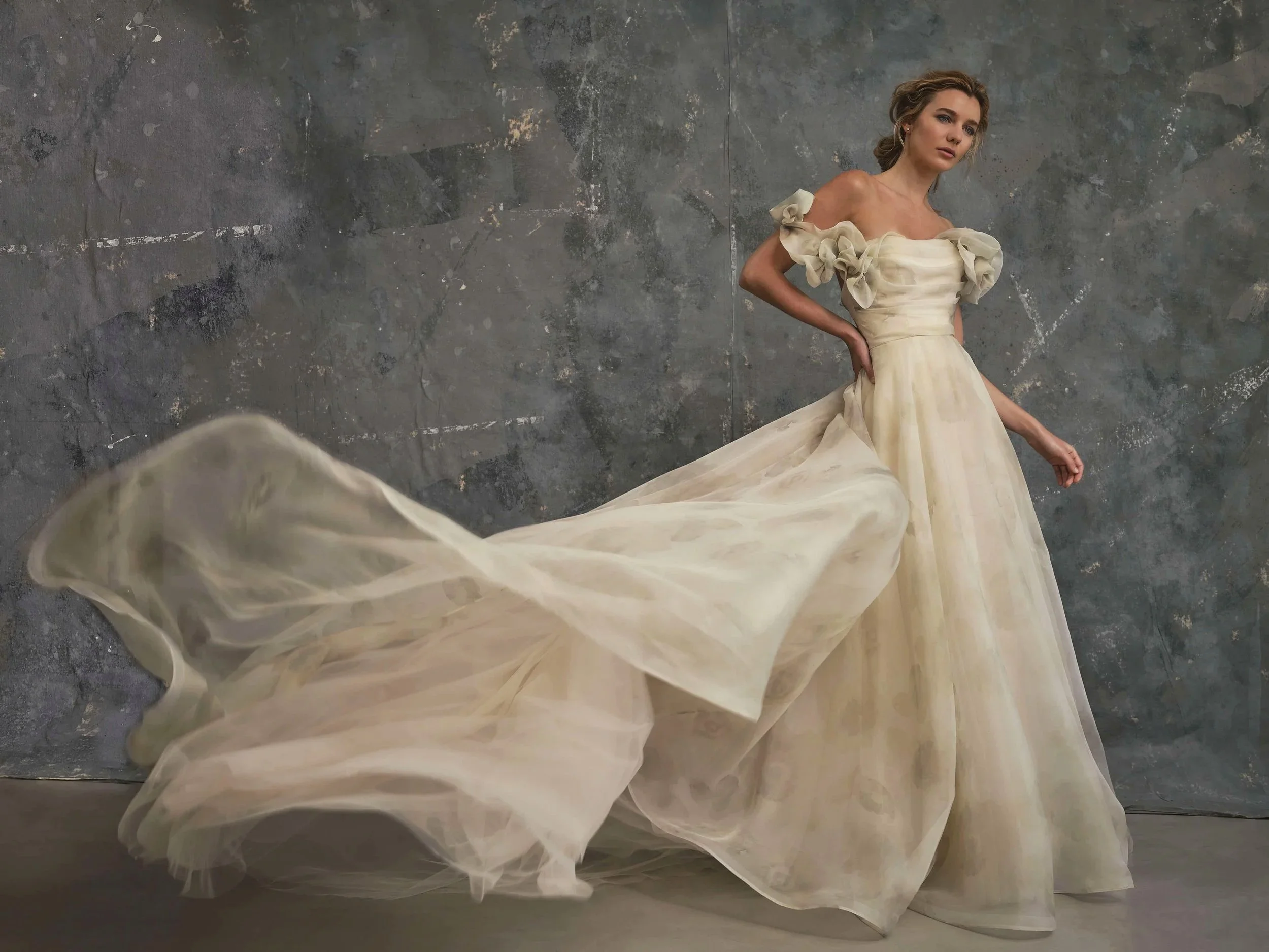Blossom floral organza blush coloured wedding dress with flowing train and sculptural off shoulder sleeves