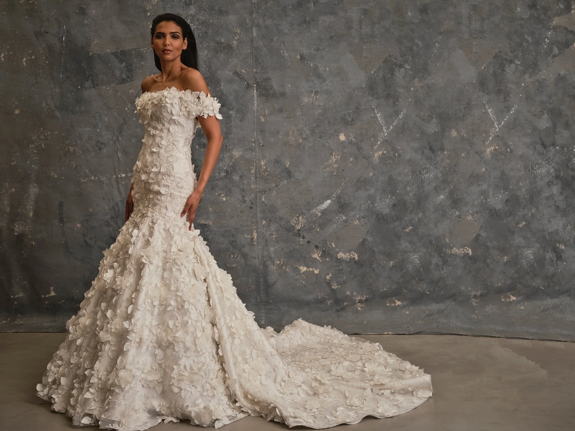 Calista wedding dress featuring three-dimensional floral appliqué and off-the-shoulder floral neckline