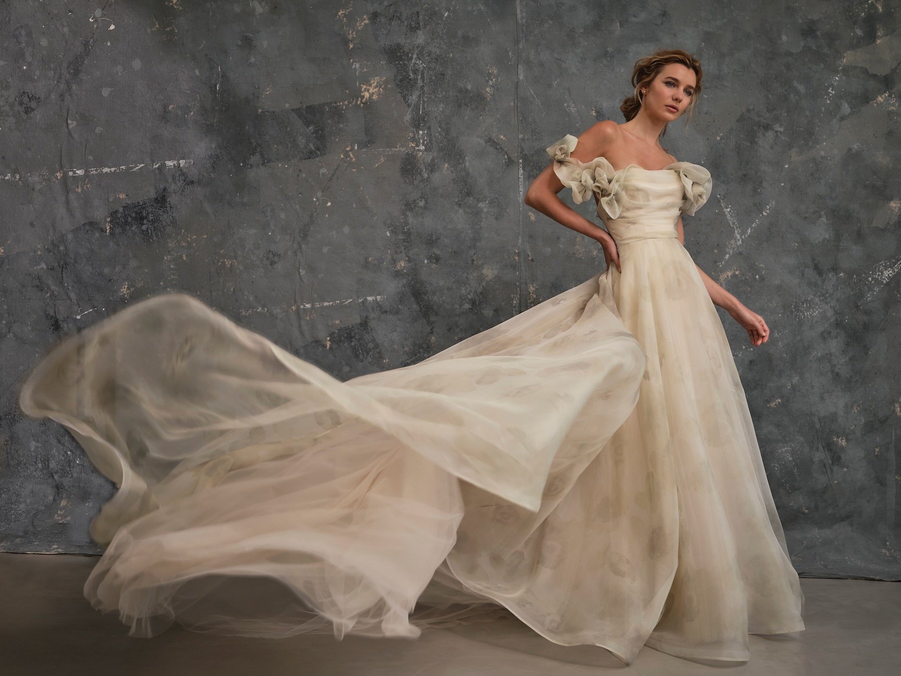 Blossom floral organza blush coloured wedding dress with flowing train and sculptural off shoulder sleeves