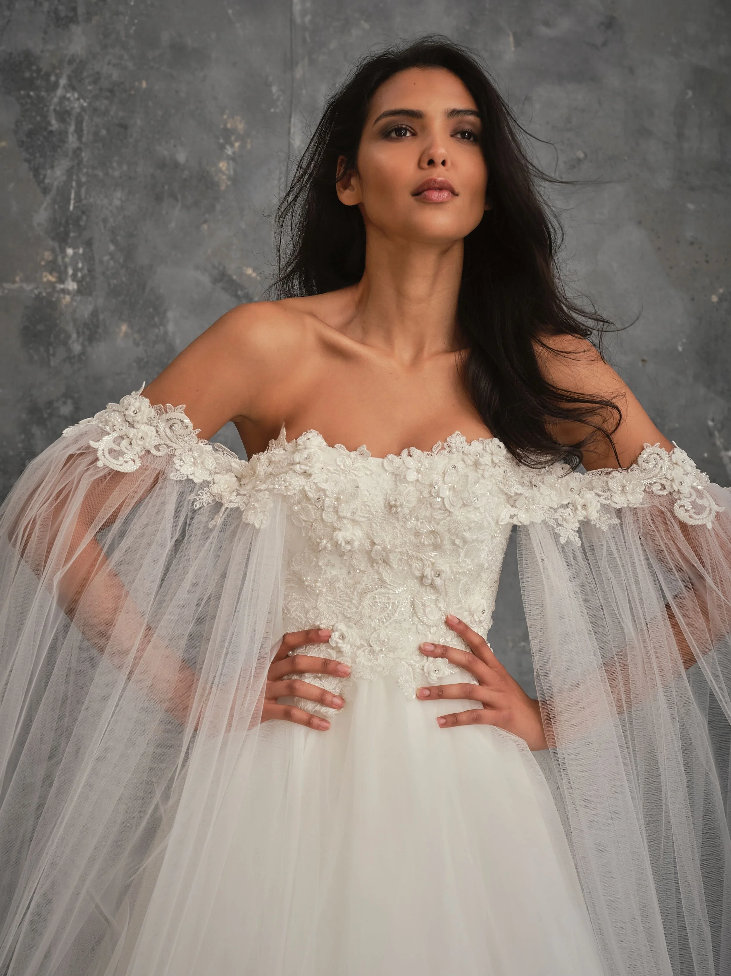 Romantic off-the-shoulder wedding dress with floral embroidered bodice and flowing tulle sleeves