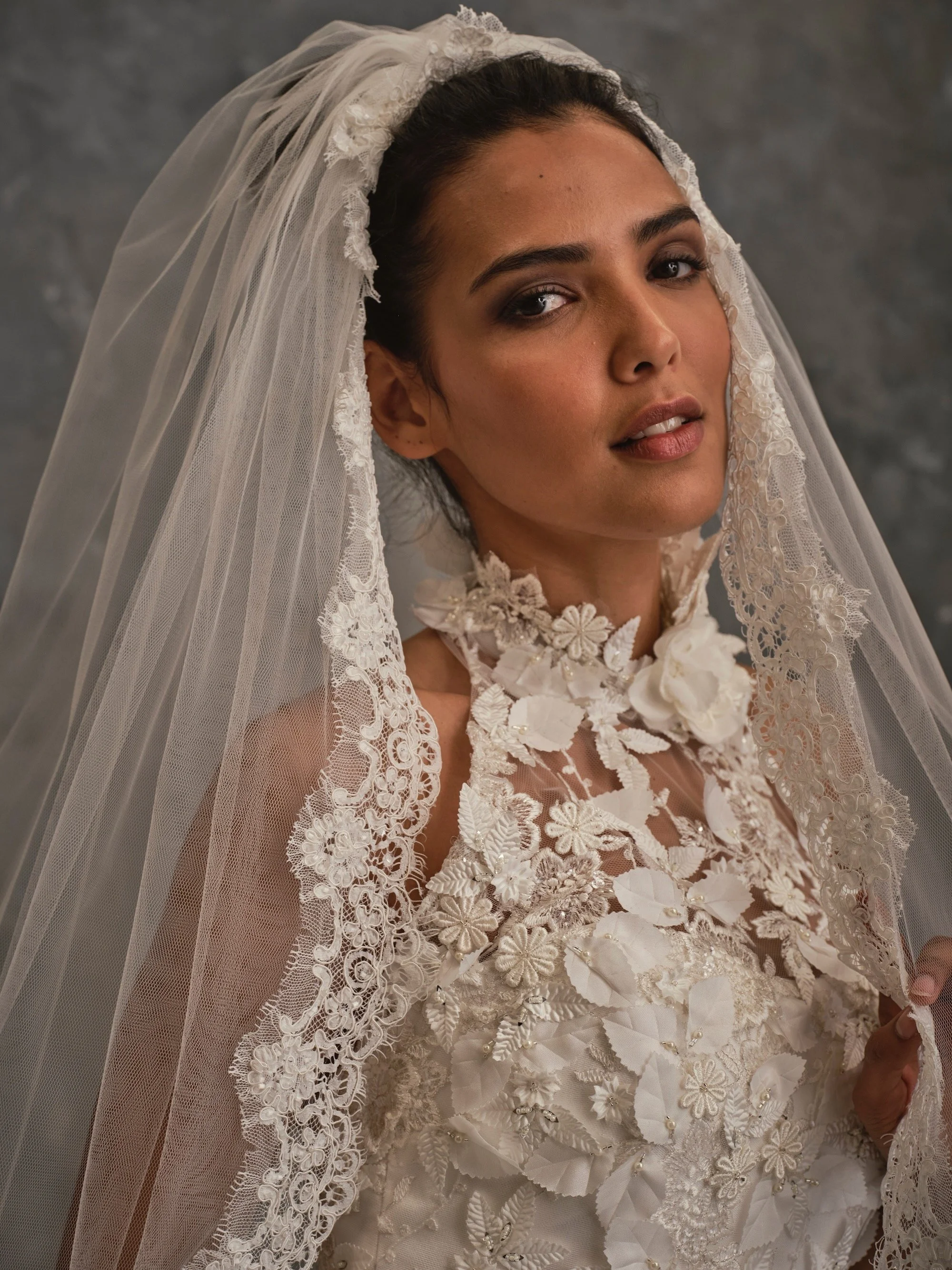 Detailed close-up of 3D floral appliqué bodice with illusion halterneck and lace tulle veil