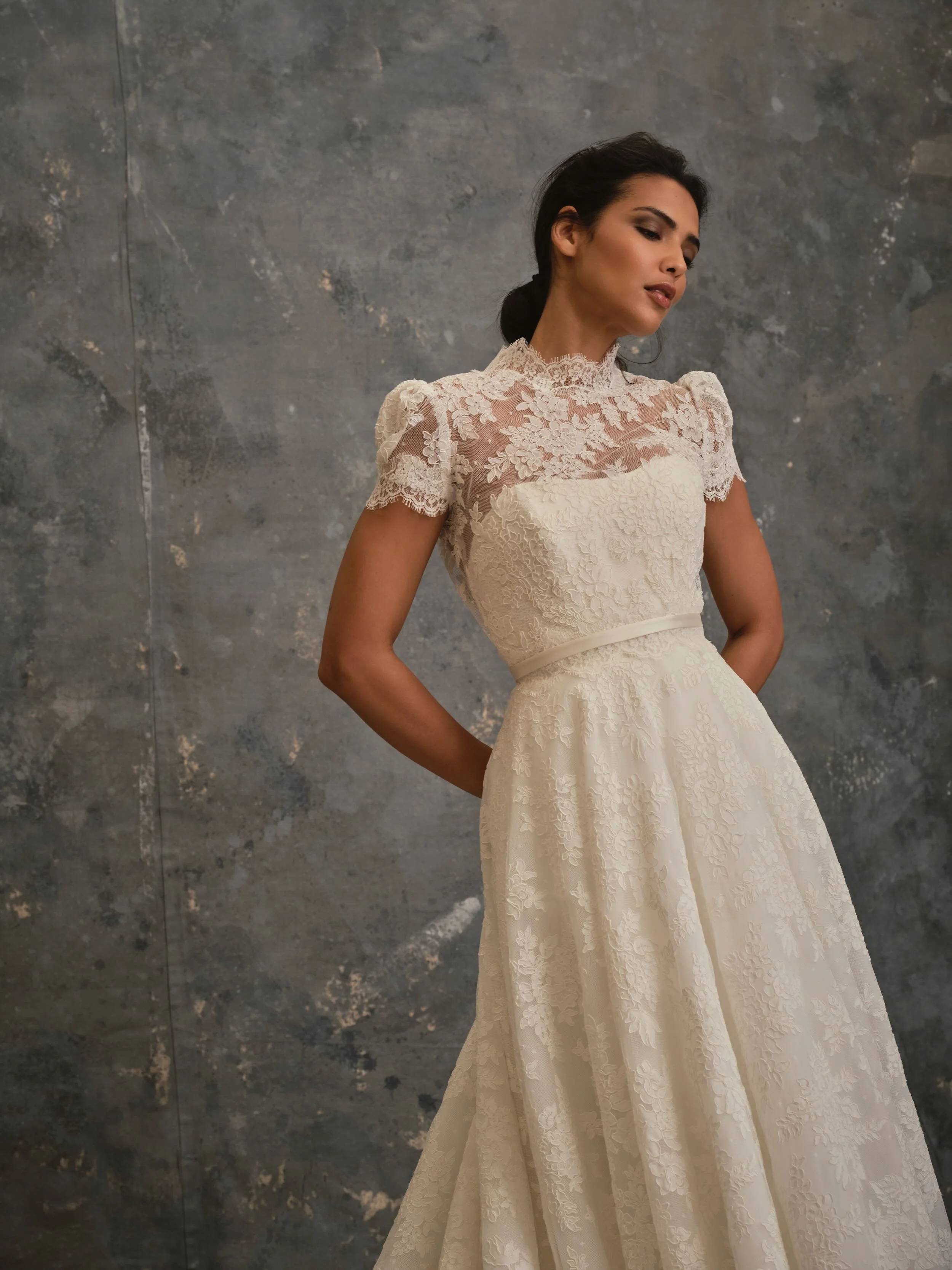 Close-up of lace bridal gown with floral lace detailing and high neckline