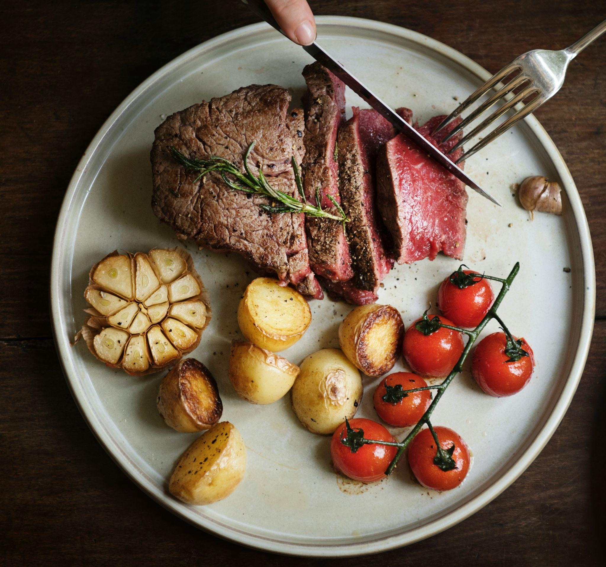 Plate of steak garlic potatoes and cherry tomatoes