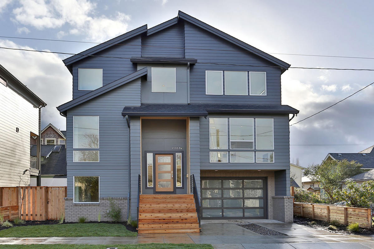 With a robust color consultation practice, we worked with both client and developer to select an exterior color palette that would accentuate the varying planes of the home while remaining subtle and refined. The addition of wood on the steps, doors, and wrapped entry adds interest and warmth.