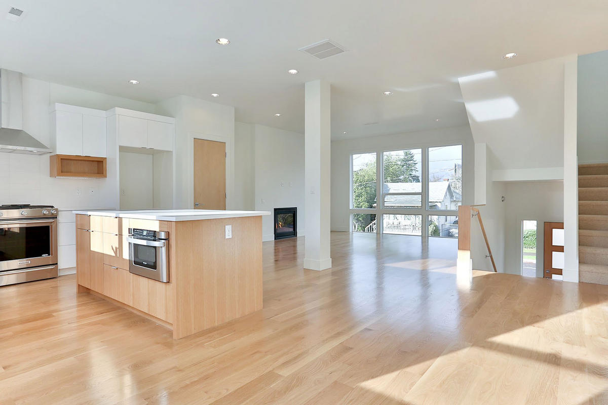 A neutral yet warm backdrop was requested by the clients for the finishes. A wide collection of curated items and art through years of travel needed to be easily integrated into the home. The contrast of multiple woods—white oak floors and cabinetry, birch doors, fir-capped handrails—lend a sense of interest and tonal warmth. Room layouts were modified from the builder's plans to create an open connection between the kitchen and living rooms.