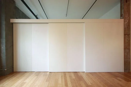 Each panel of the sliding wall is painted a slightly different tone of white to add interest.