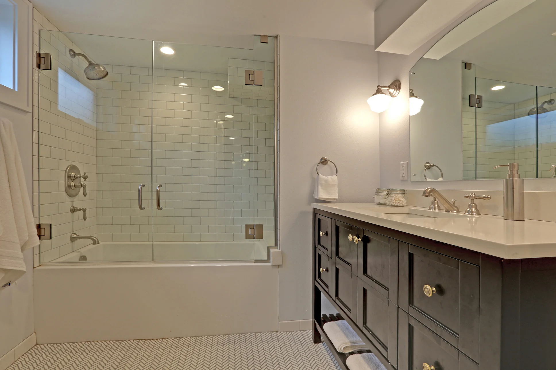 Radiant-heat herringbone Ann Sacks tile in the bathroom, Rohl fixtures, and a deep soaking tub create a destination and spa-like environment in the new bathroom.