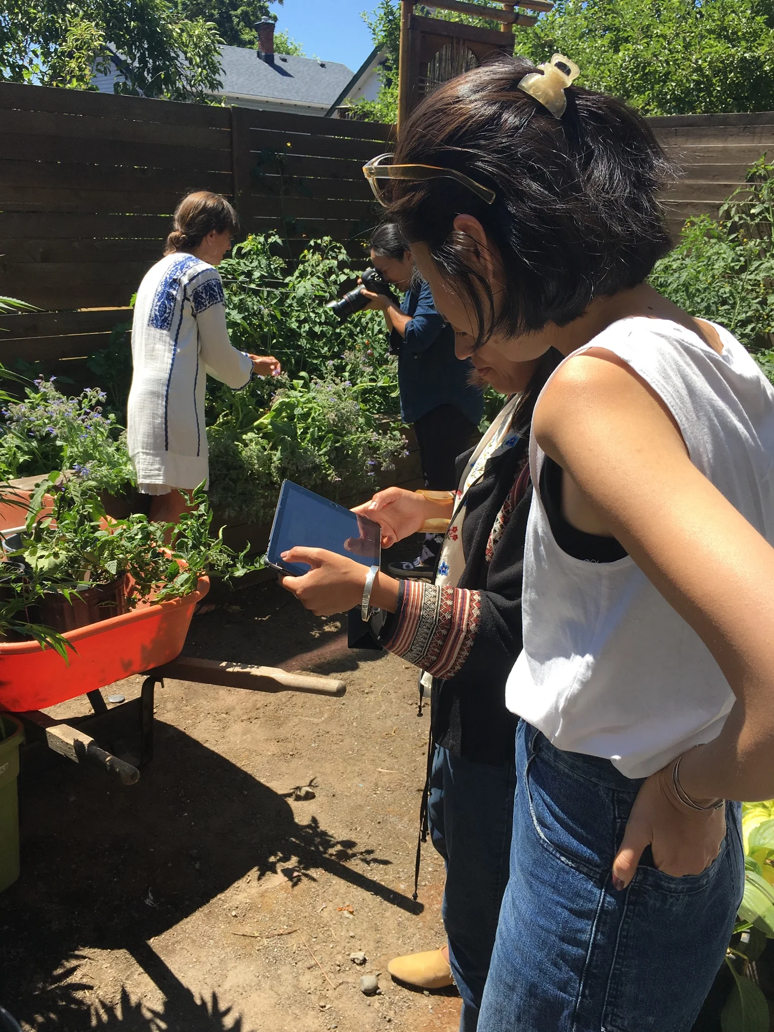 Of course everyone works in their garden in a hand embroidered white linen dress, photo shoots can be deceiving. In this behind the scenes moment the photographer has Shannon posing with her freshly picked tomatoes while the art director and editor supervise via their ipad.