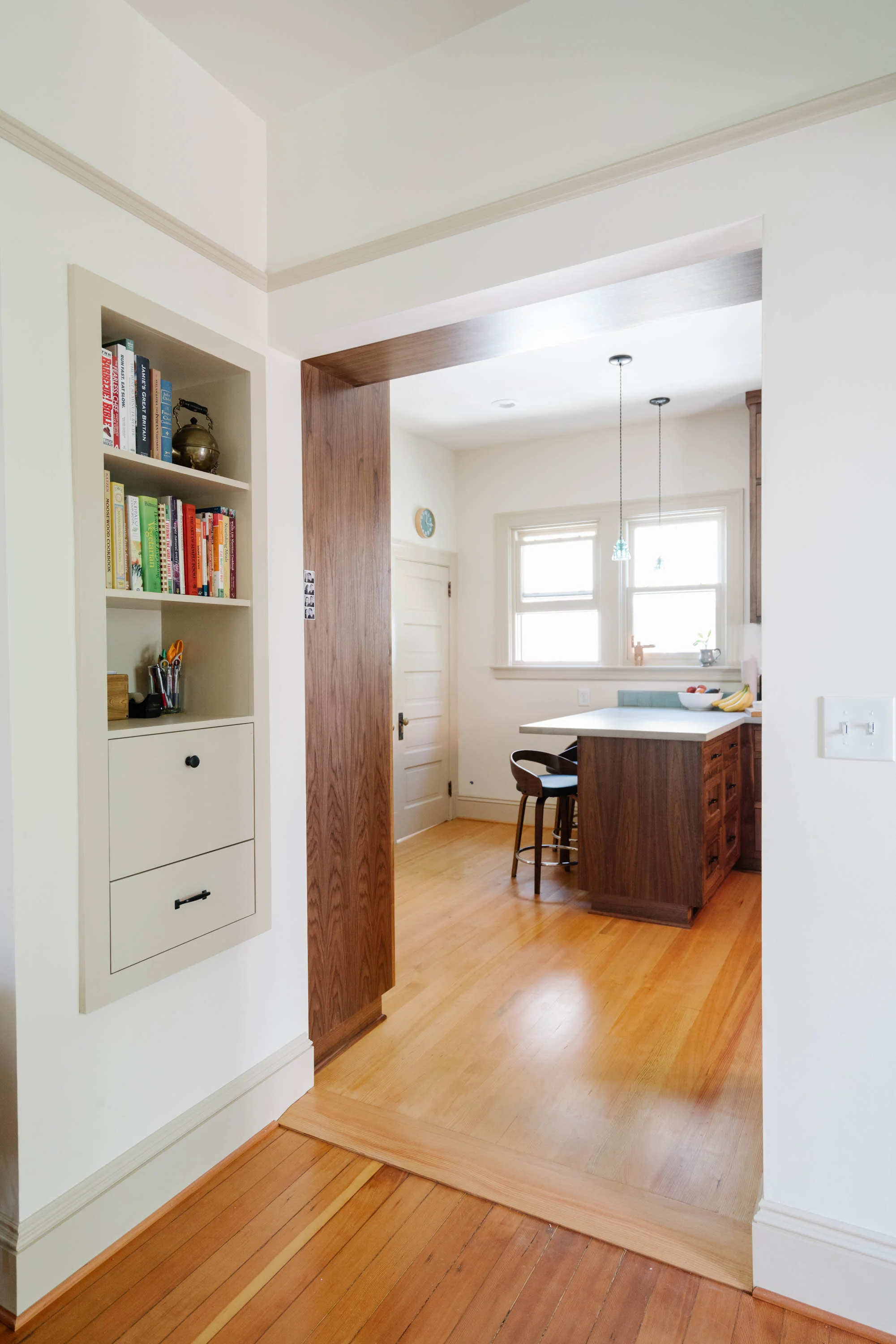 A wide opening from the kitchen into the dining room provides good connectivity. Cabinets and an overhead display shelf flank the passage. Built-ins in unique locations optimize storage.