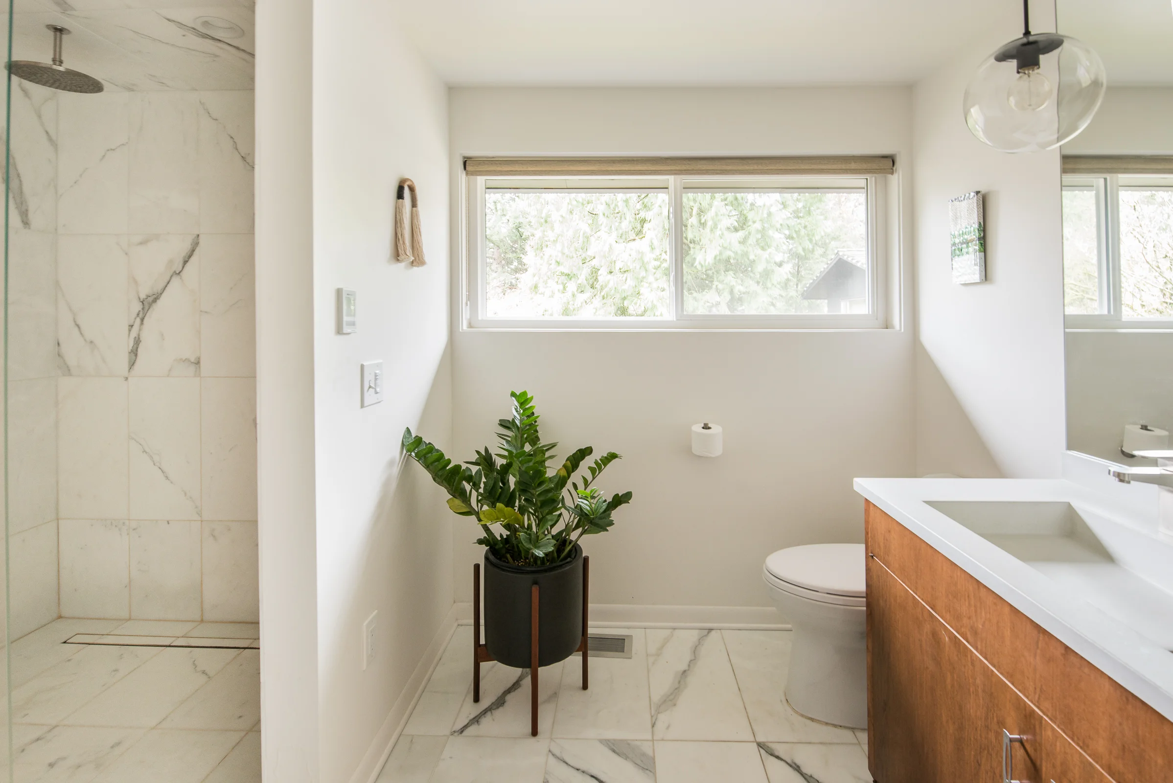Master bath update with restored cabinetry. Calcutta marble on floors and shower walls is always a perfect choice, especially when paired with the Cement Elegance white countertops.