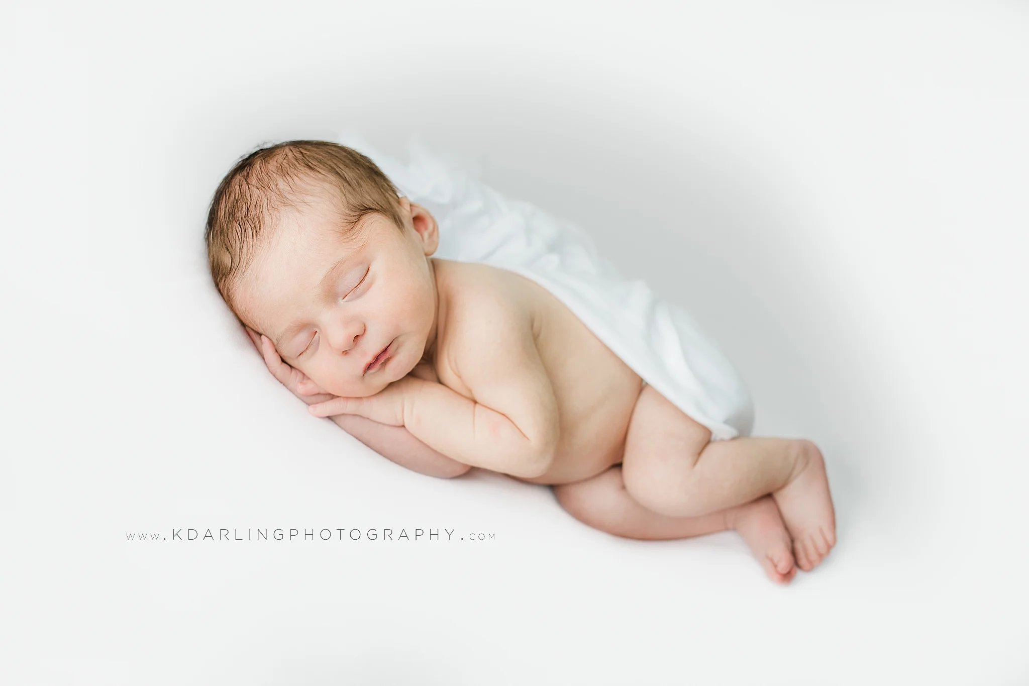 Newborn baby boy laying on side
