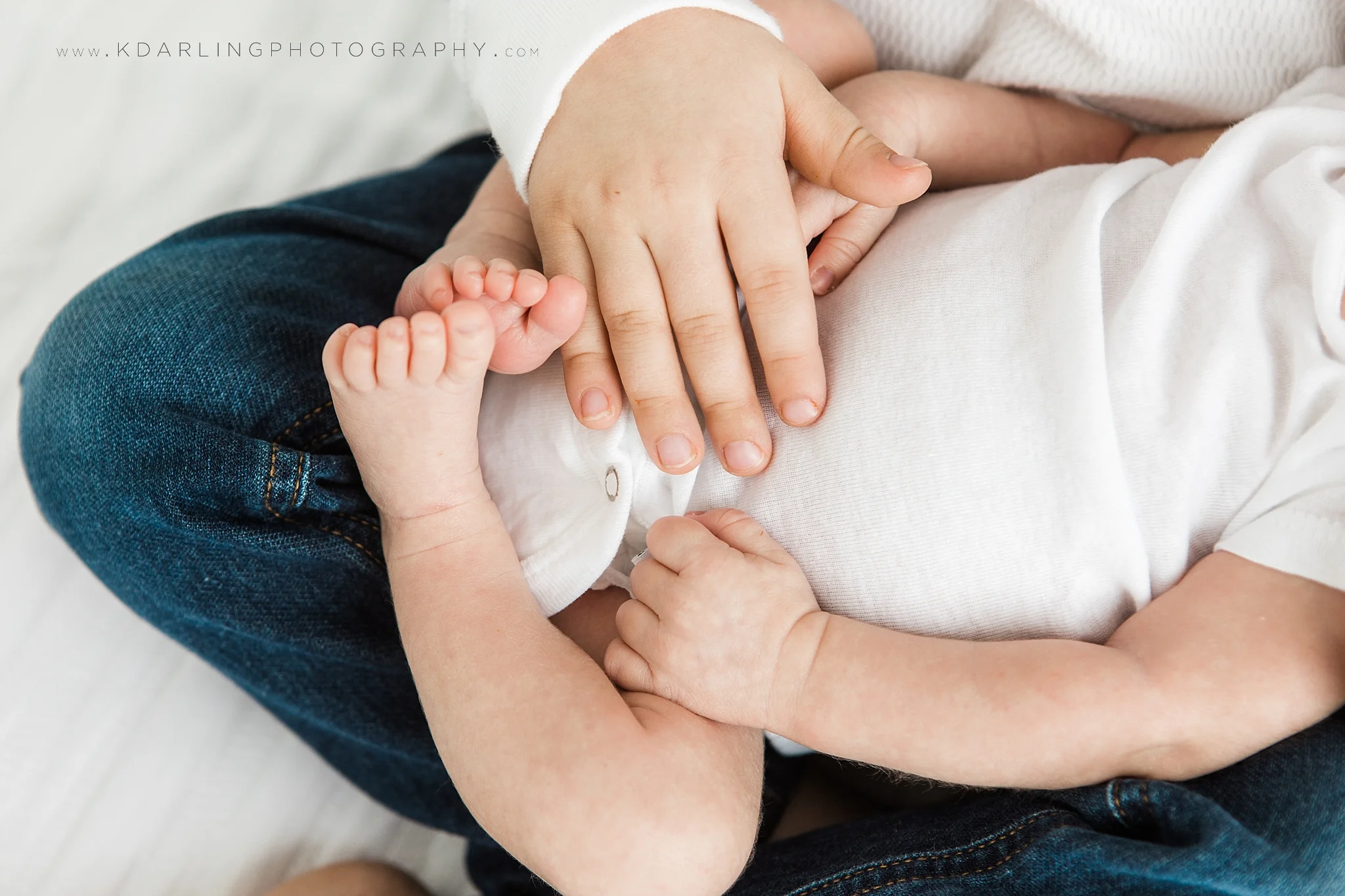 Newborn baby with brother's hands