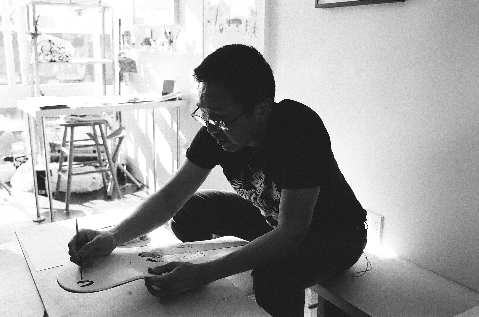 Jeffrey Cheung painting a skate deck.
