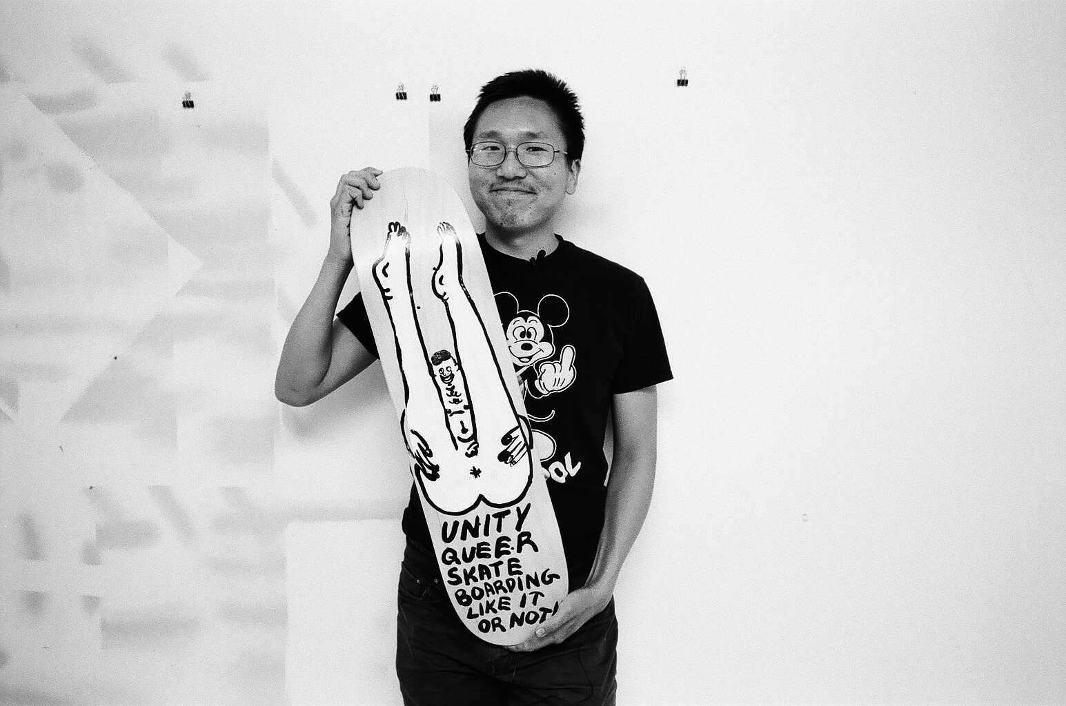 Jeffrey Cheung holding a skate deck he painted.