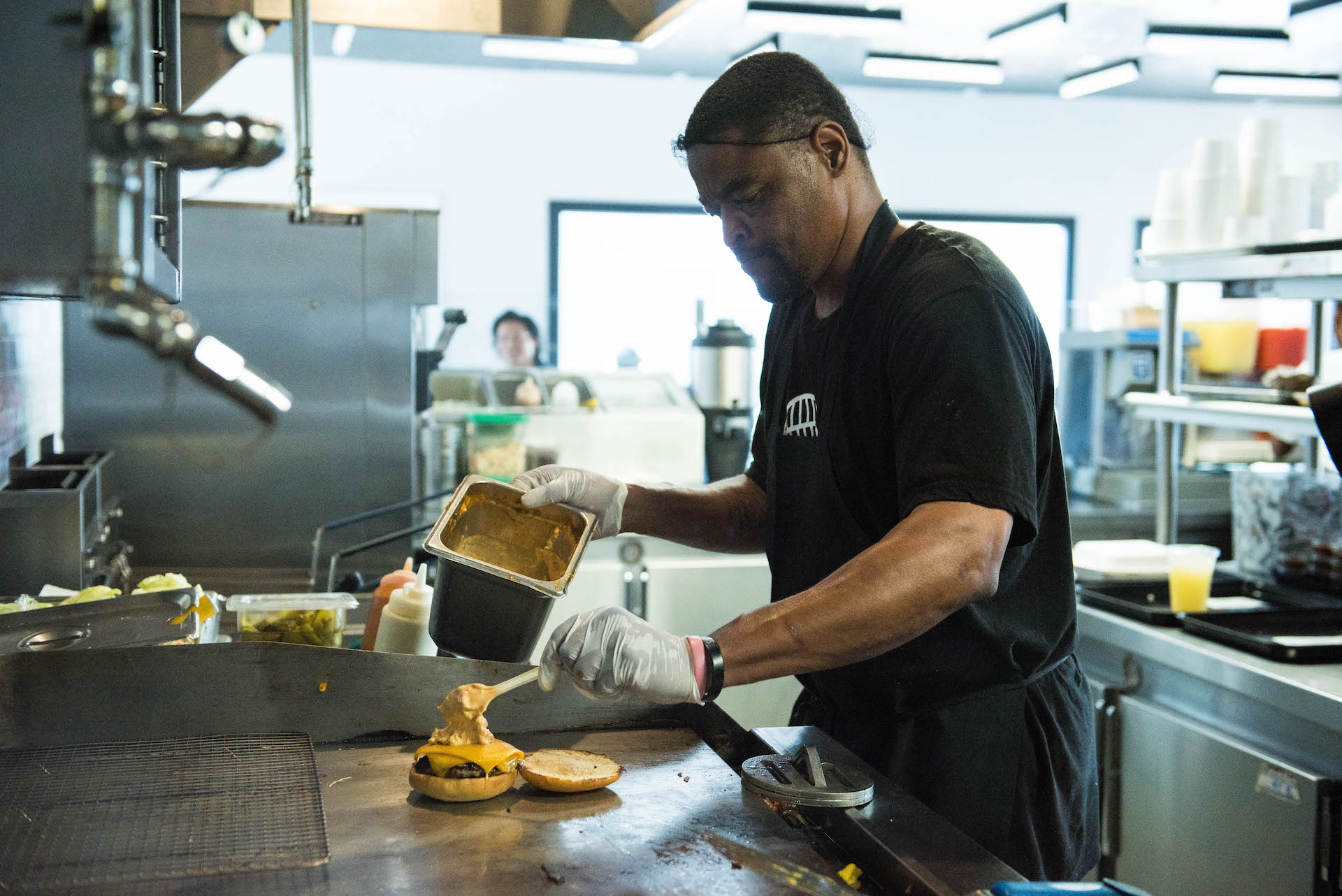 The grill master prepping a delicious Locol cheeseburger.