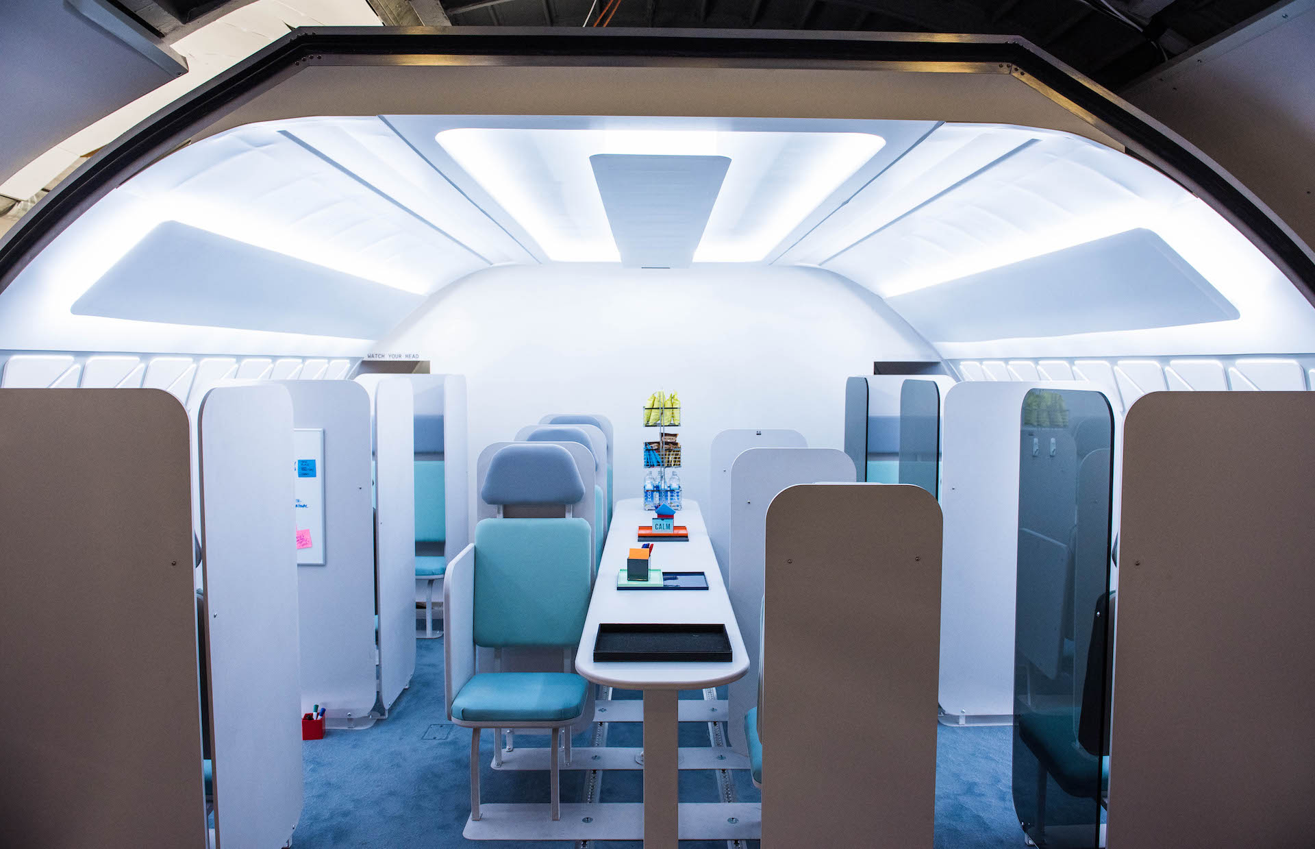 A business center on the plane. These chairs are designed for relaxation and work. There are also private cubicles on the sides for extra privacy.