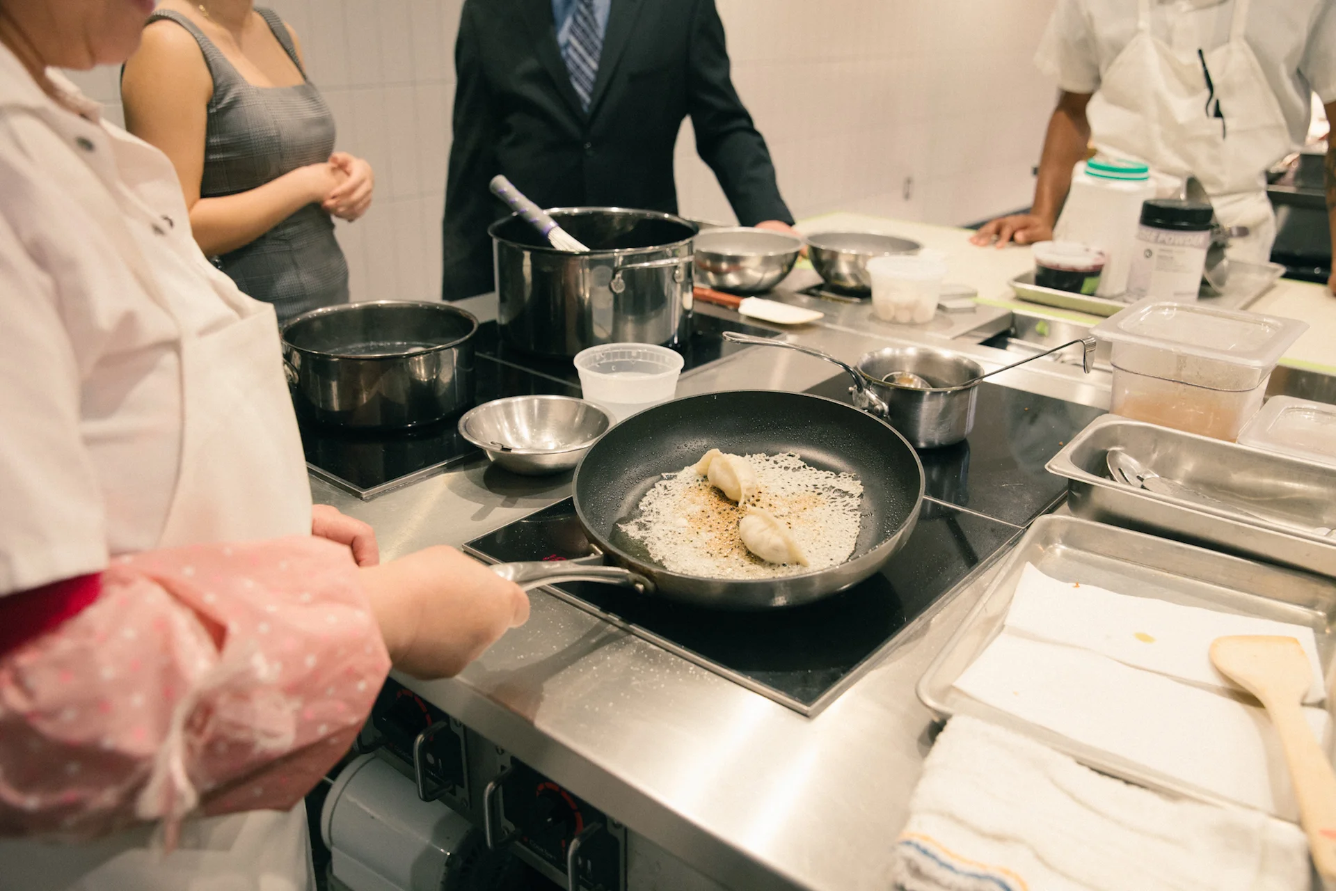 A cook fries the Foie Gras potstickers.