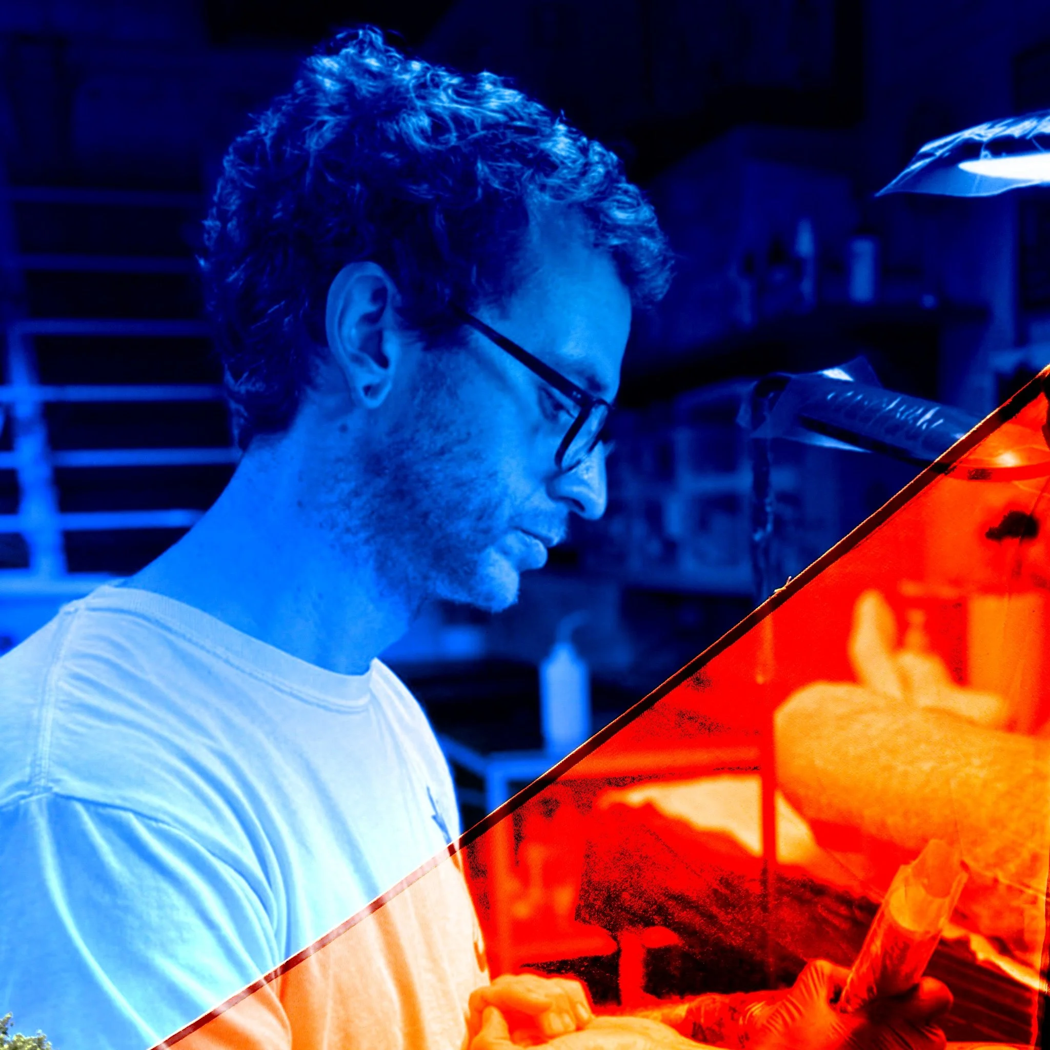 A man wearing glasses and a white shirt, working in a kitchen or workshop, with an orange overlay on part of the image.