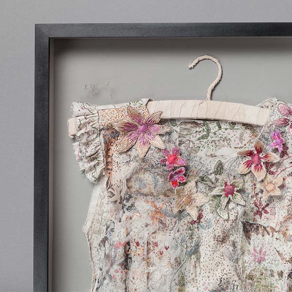 Box framed textile artwork suspended on provided wrapped coat hanger. Museum glass.