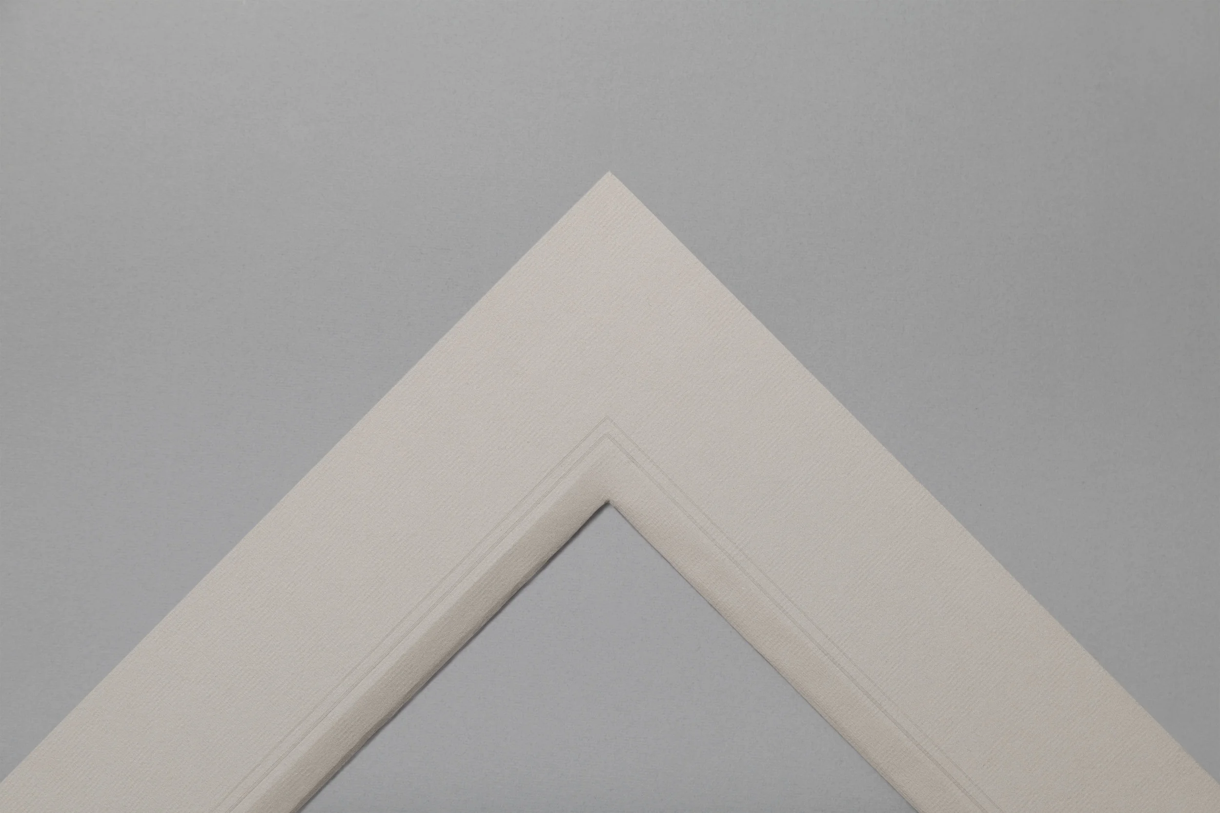 Double thickness, grey paper hand wrapped mount with embossed lines