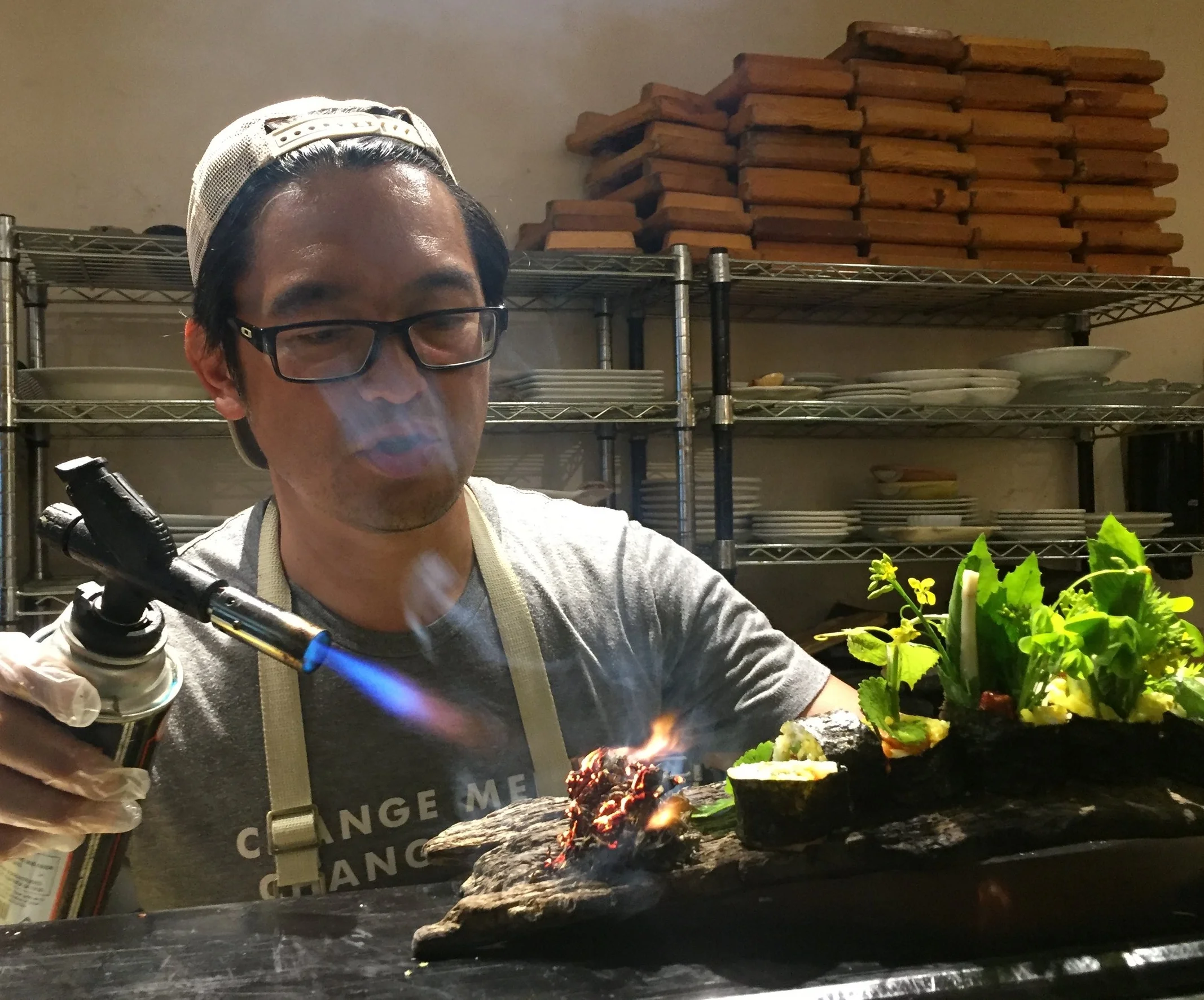 Chef Bun Lai of Miya's Sushi in New Haven, CT burns mugwort to connect with indigenous cultures many of which us this "weed" to enhance spiritual experiences and dreams - on this sushi roll platter of wild foraged weeds and sustainable seafood.