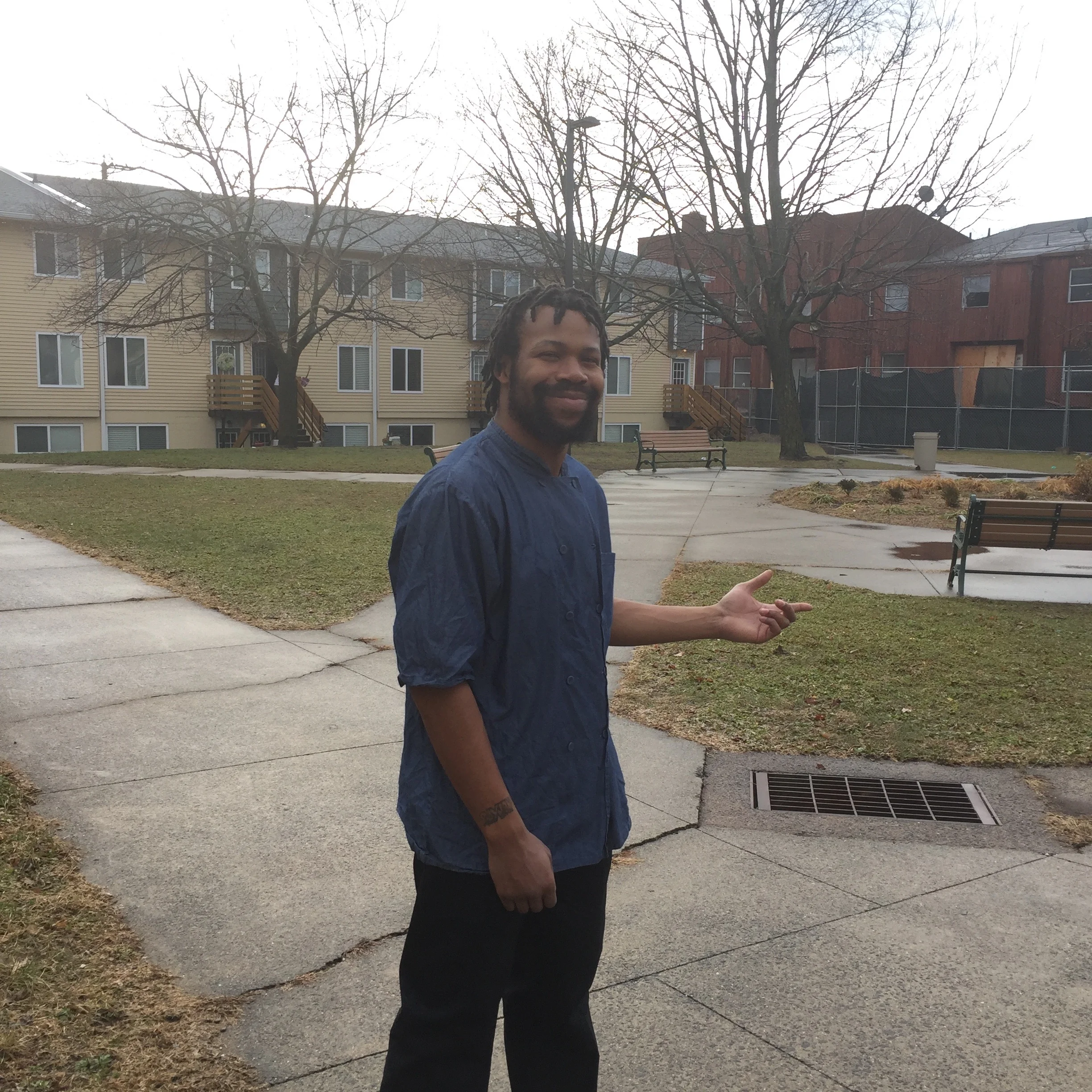 Greg showing me his garden and the shared courtyard behind his home, where he hopes to grow even more food.