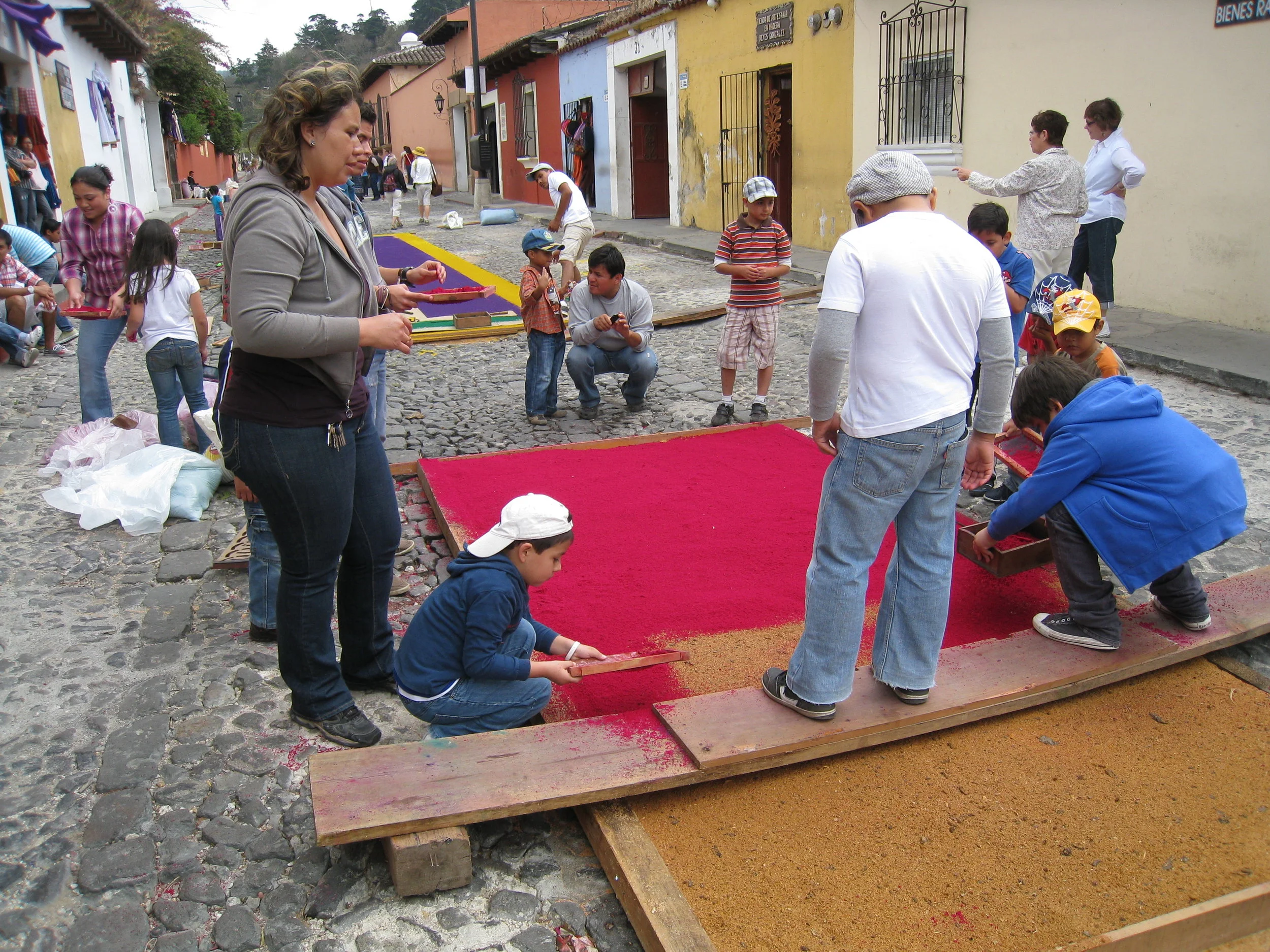  Antigua 2012--Calle 3--Putting Alfombras (Rugs) in the street in honor of the procession. These are designed and made of colored sawdust, flowers and other plants, by the neighbors 