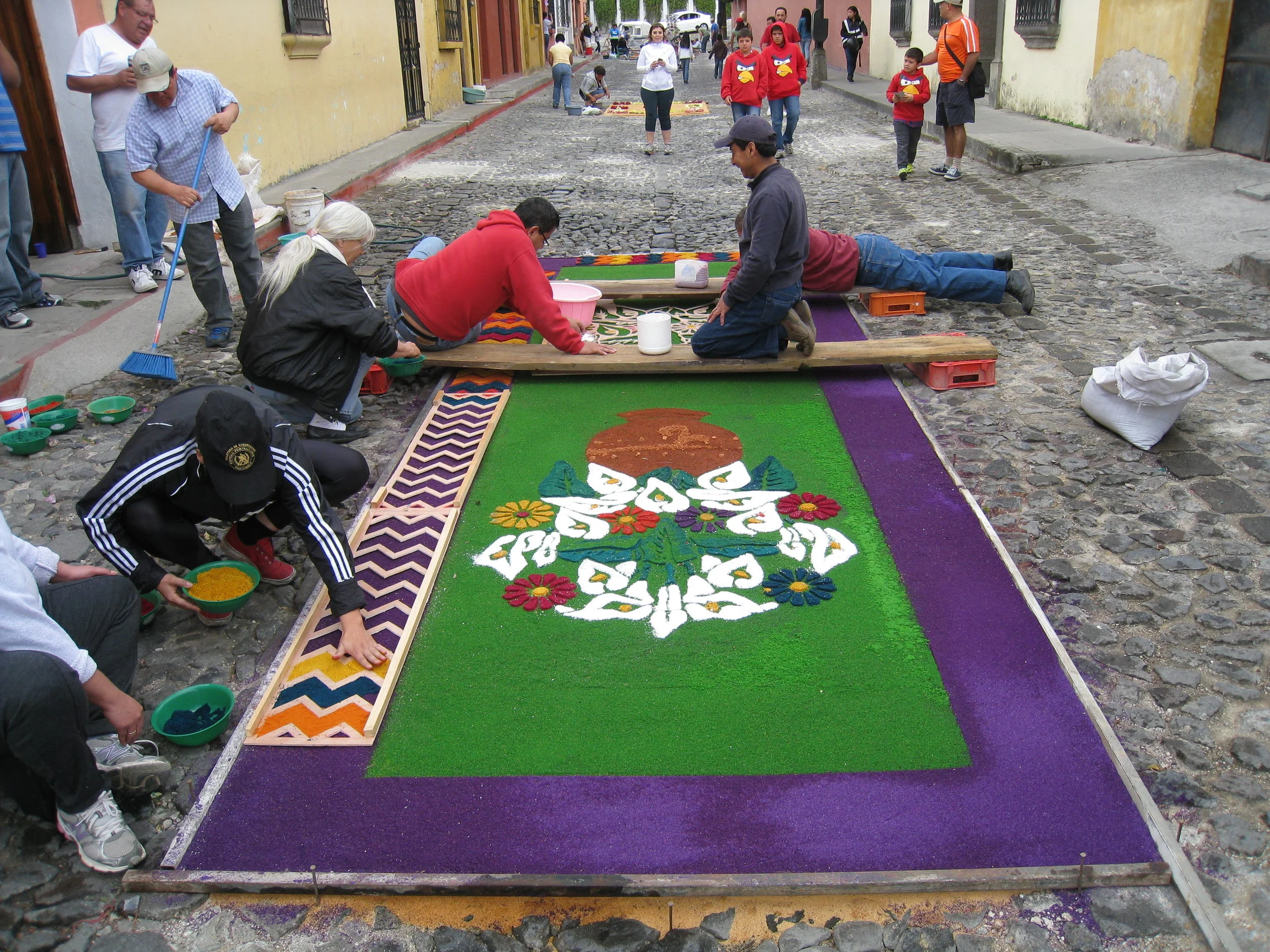  Antigua--Calle 3--Putting Alfombras (Rugs) in the street in honor of the procession. These are designed and made of colored sawdust, flowers and other plants, by the neighbors. 