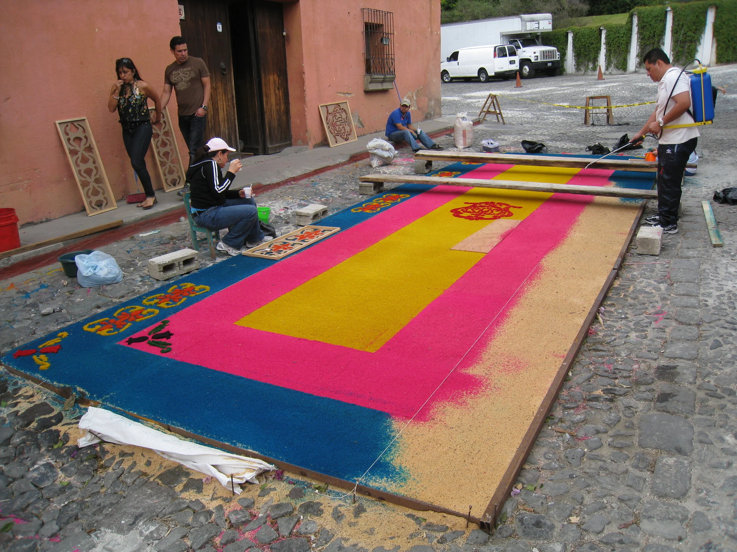  Antigua--Calle 3--Putting Alfombras (Rugs) in the street in honor of the procession. These are designed and made of colored sawdust, flowers and other plants, by the neighbors. 