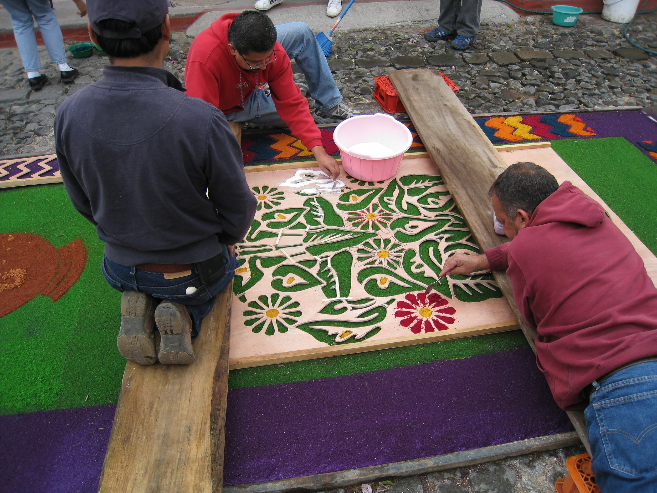  Antigua--Calle 3--Putting Alfombras (Rugs) in the street in honor of the procession. These are designed and made of colored sawdust, flowers and other plants, by the neighbors. 