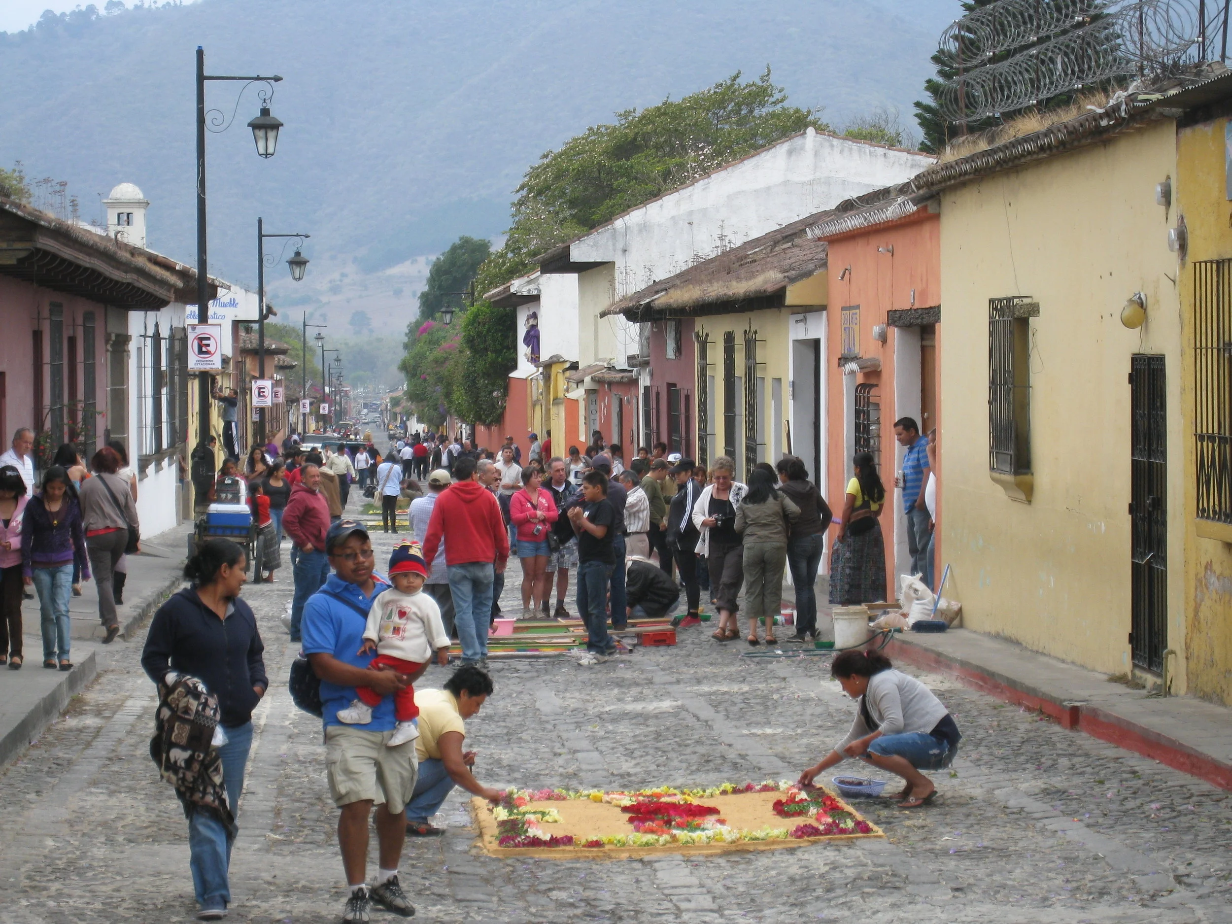  Antigua--Calle 3--Putting Alfombras (Rugs) in the street in honor of the procession. These are designed and made of colored sawdust, flowers and other plants, by the neighbors. 