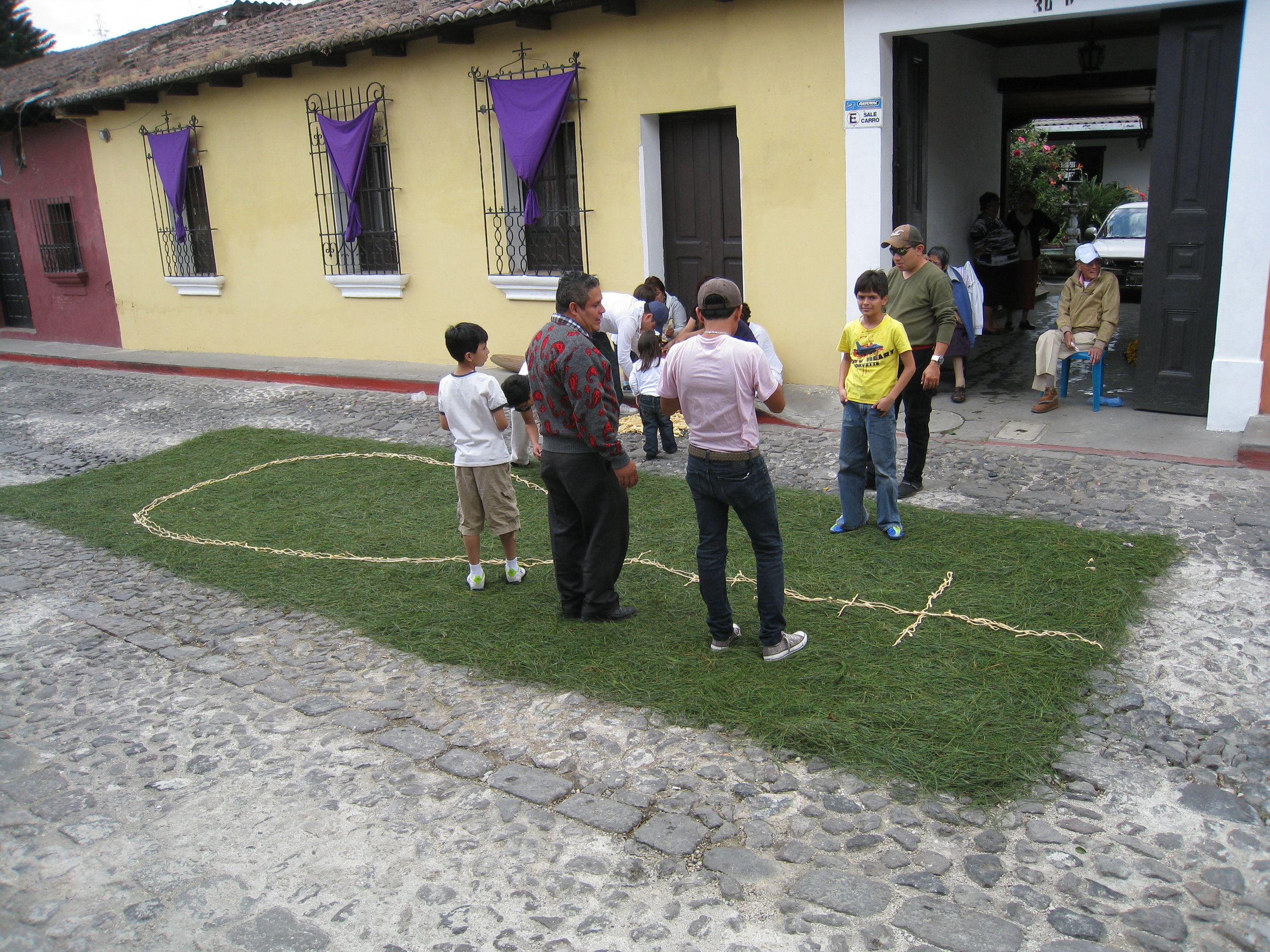  Antigua--Calle 3--Putting Alfombras (Rugs) in the street in honor of the procession. These are designed and made of colored sawdust, flowers and other plants, by the neighbors. This one is based on pine needles, a Mayan tradition 