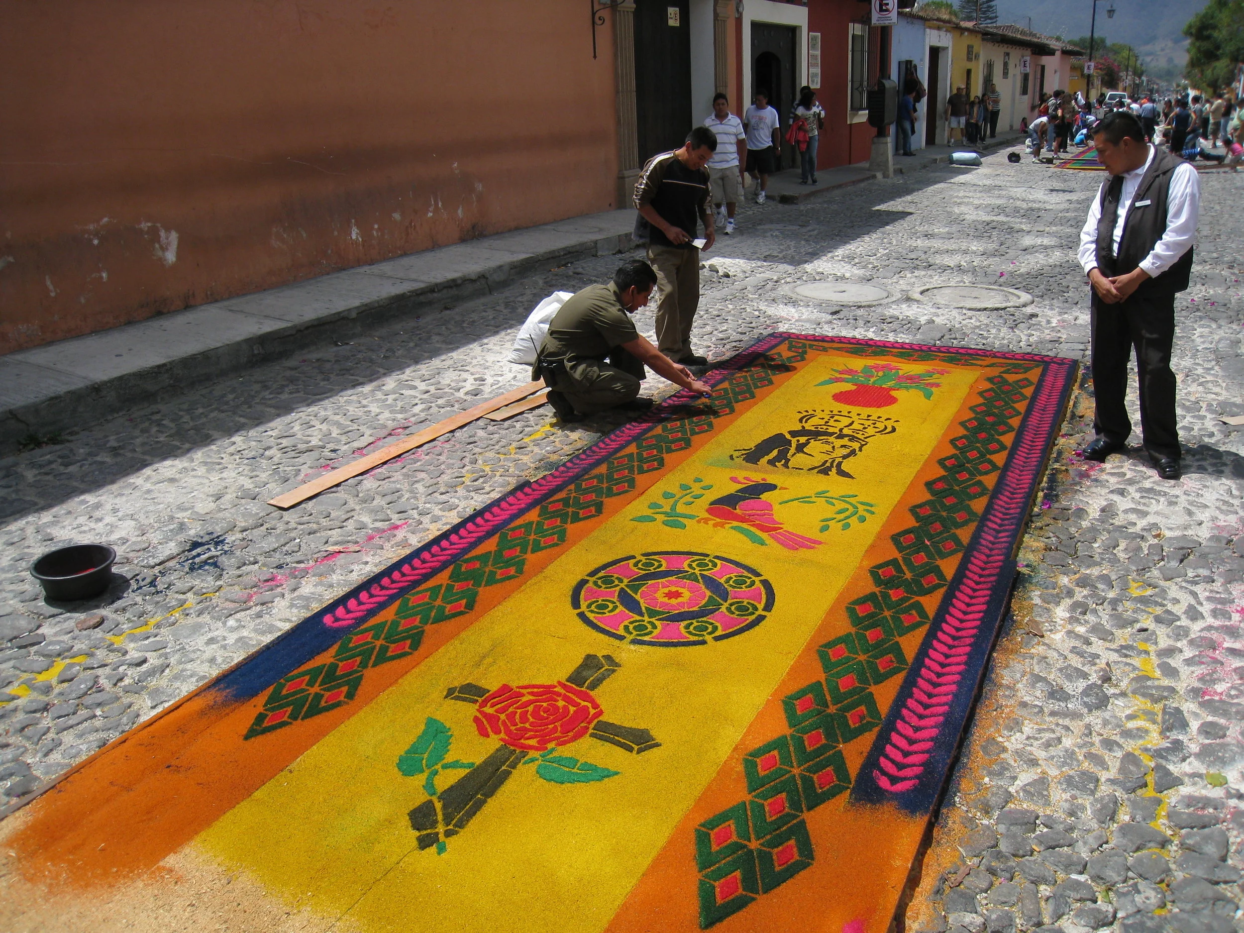  Antigua--Calle 3--Putting Alfombras (Rugs) in the street in honor of the procession. These are designed and made of colored sawdust, flowers and other plants, by the neighbors. 