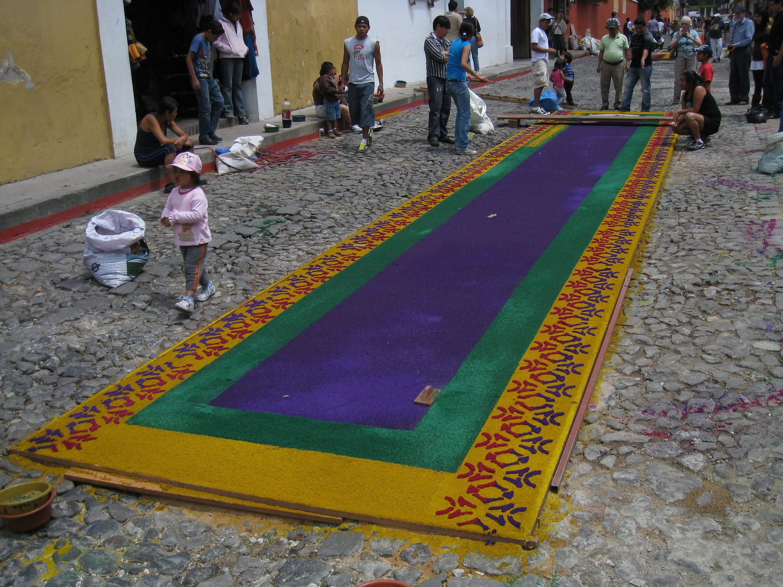  Antigua--Calle 3--Putting Alfombras (Rugs) in the street in honor of the procession. These are designed and made of colored sawdust, flowers and other plants, by the neighbors. 
