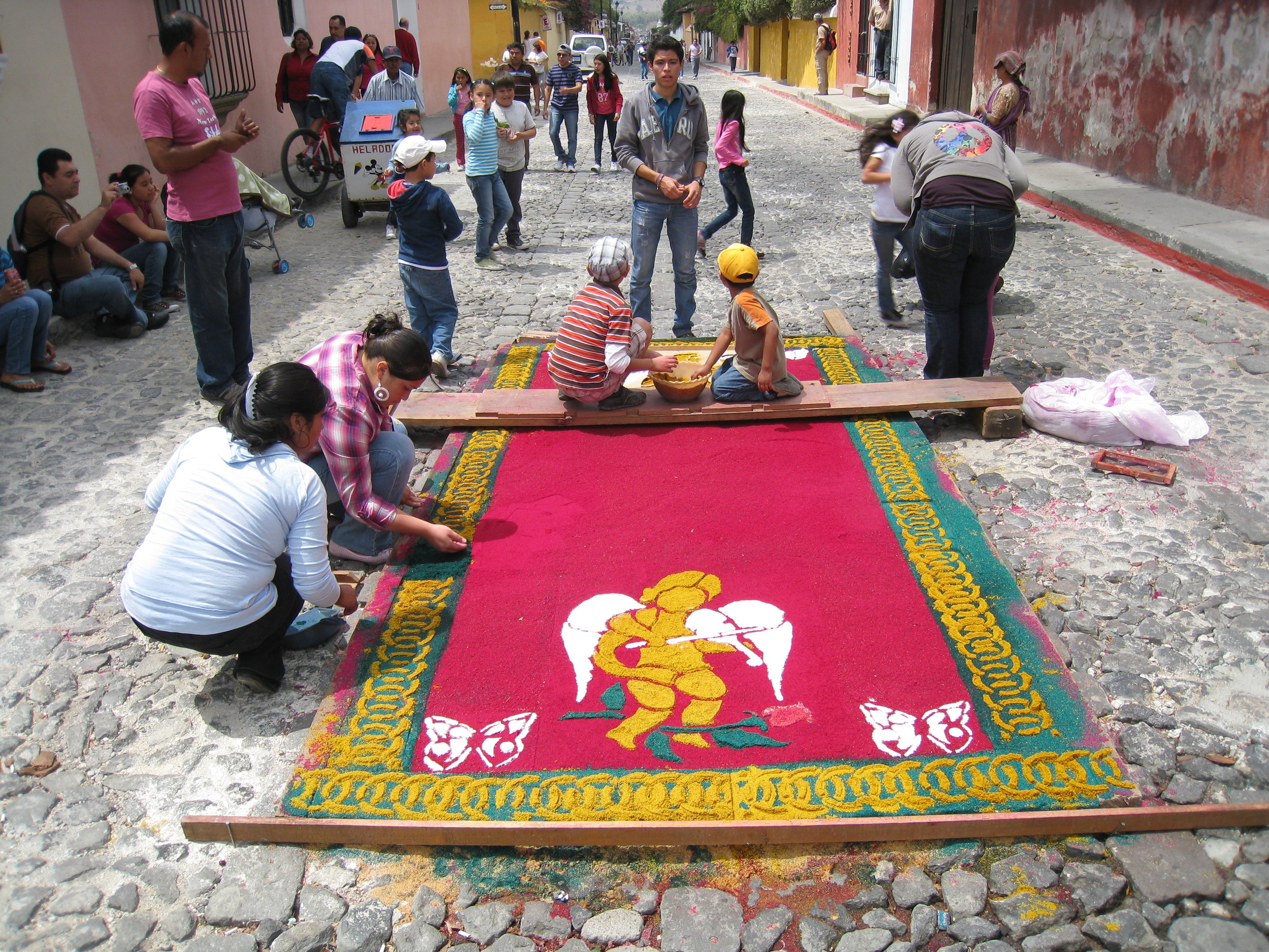  Antigua--Calle 3--Putting Alfombras (Rugs) in the street in honor of the procession. These are designed and made of colored sawdust, flowers and other plants, by the neighbors. 