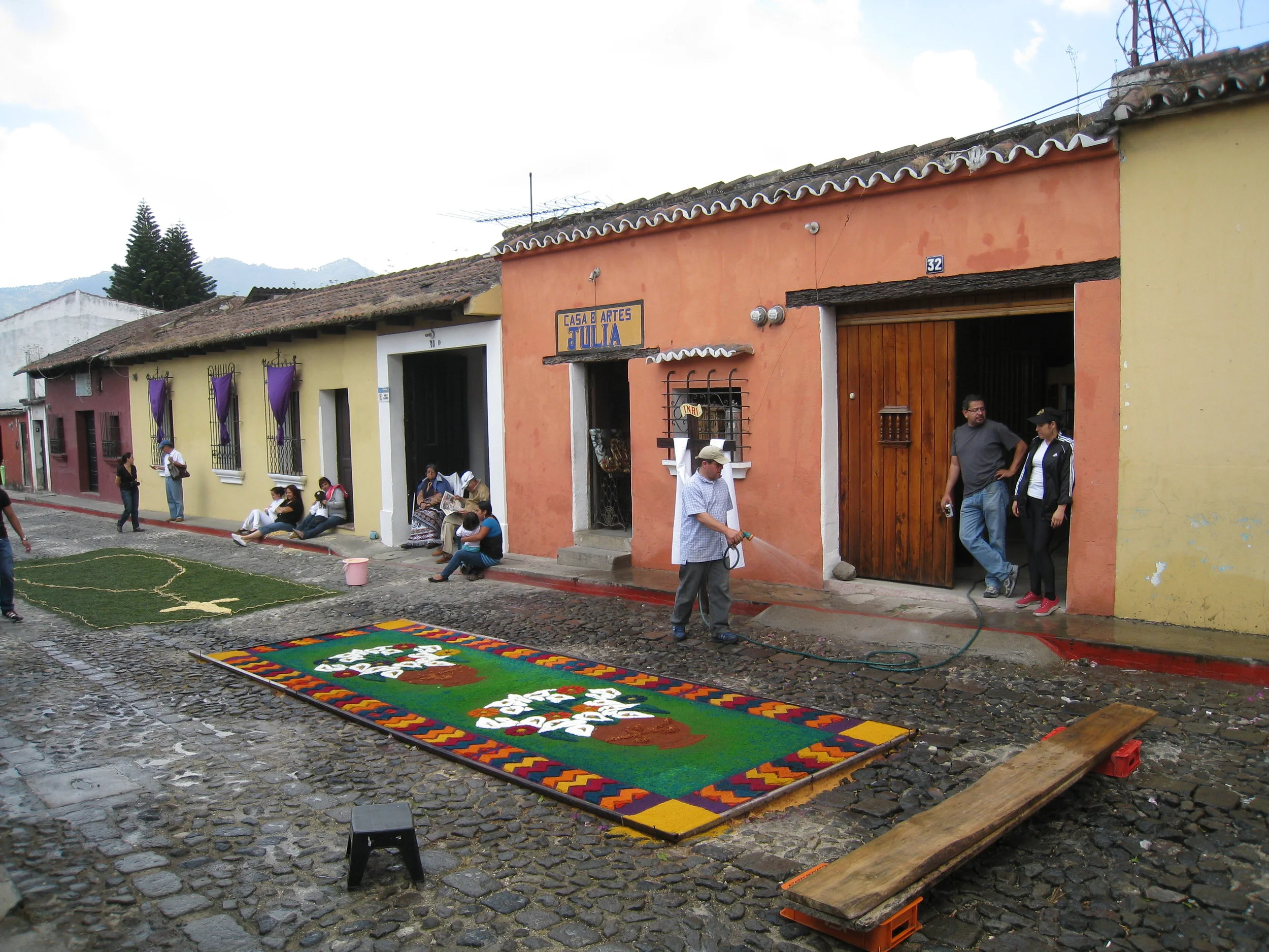  Antigua--Calle 3--Putting Alfombras (Rugs) in the street in honor of the procession. These are designed and made of colored sawdust, flowers and other plants, by the neighbors. 