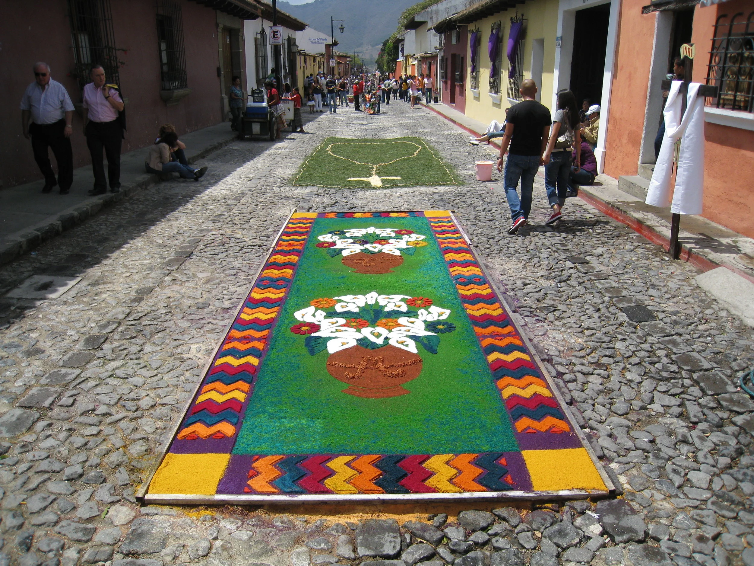  Antigua--Calle 3--Putting Alfombras (Rugs) in the street in honor of the procession. These are designed and made of colored sawdust, flowers and other plants, by the neighbors. 