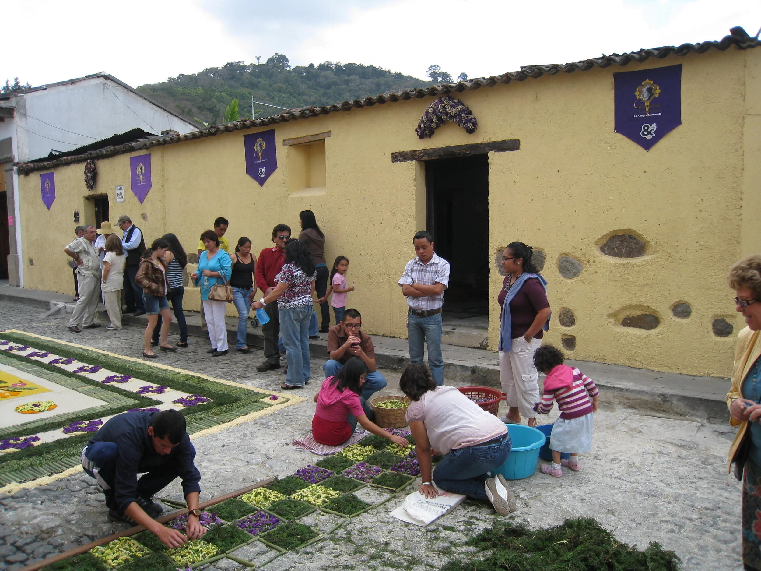  Antigua--Calle 3--Putting Alfombras (Rugs) in the street in honor of the procession. These are designed and made of colored sawdust, flowers and other plants, by the neighbors. 